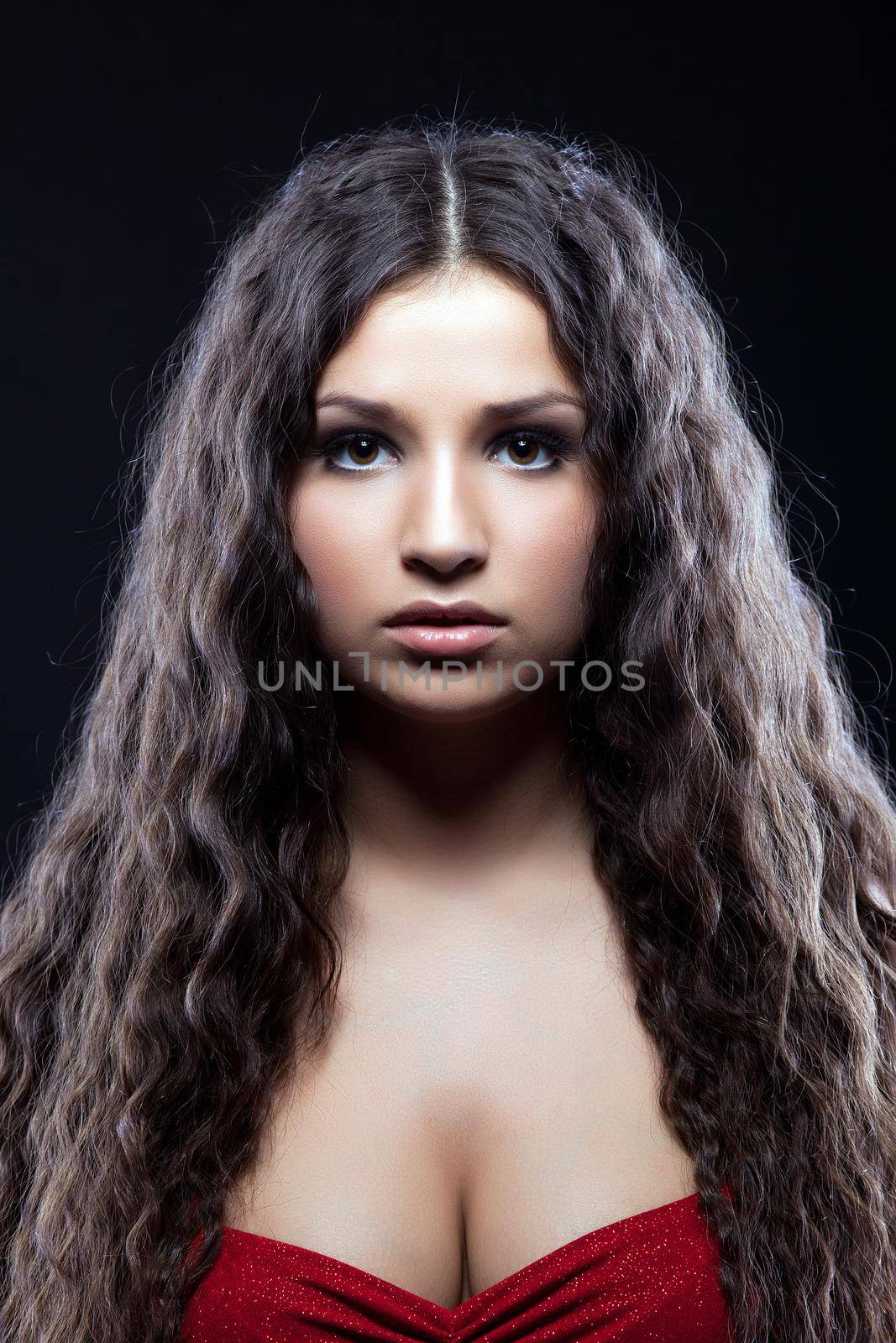 Young beautiful serious girl with curly hair by rivertime