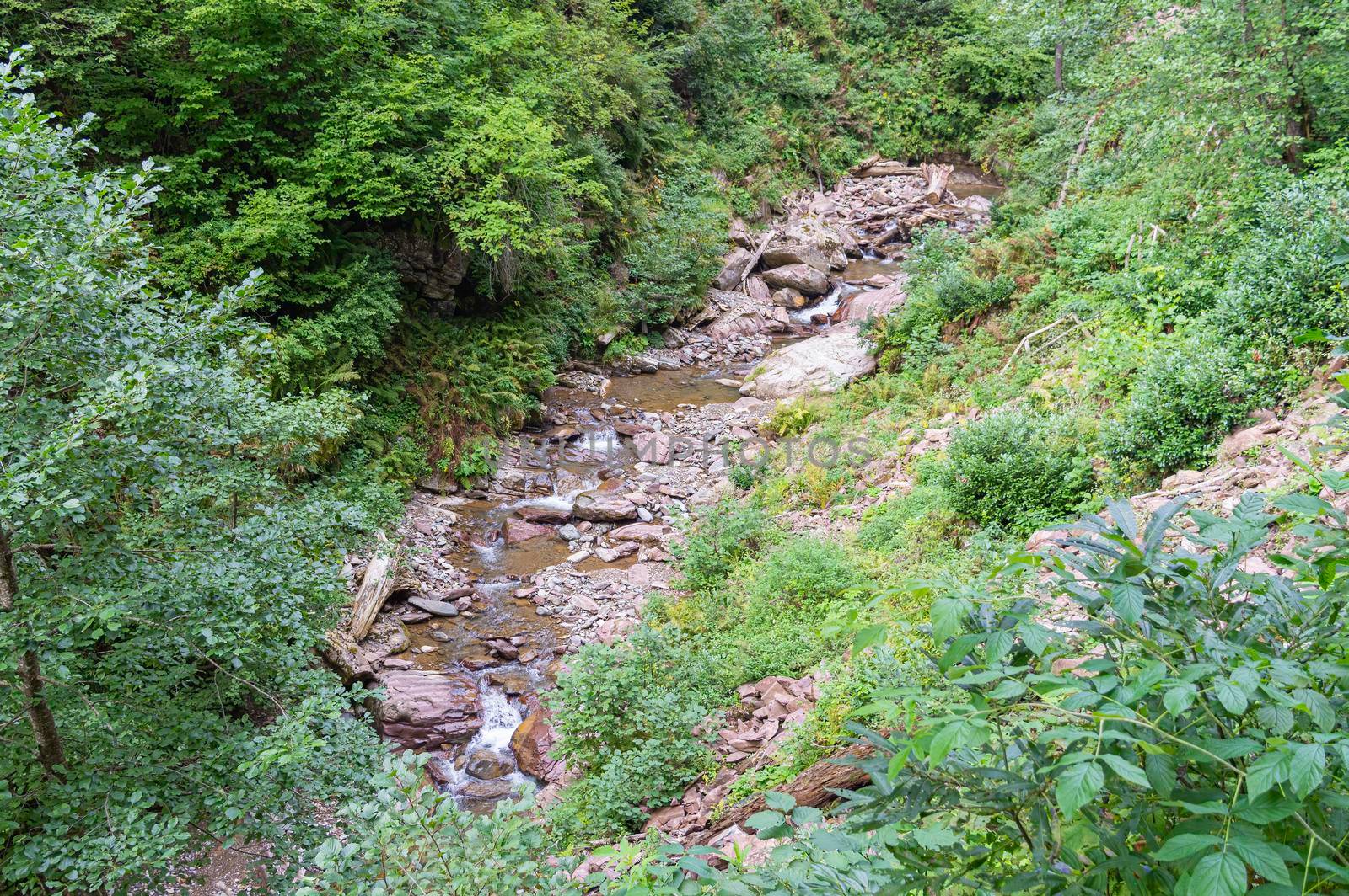 waterfall in the mountains of the mountain river. sochi rosa khutor mendelikha waterfalls park. photo