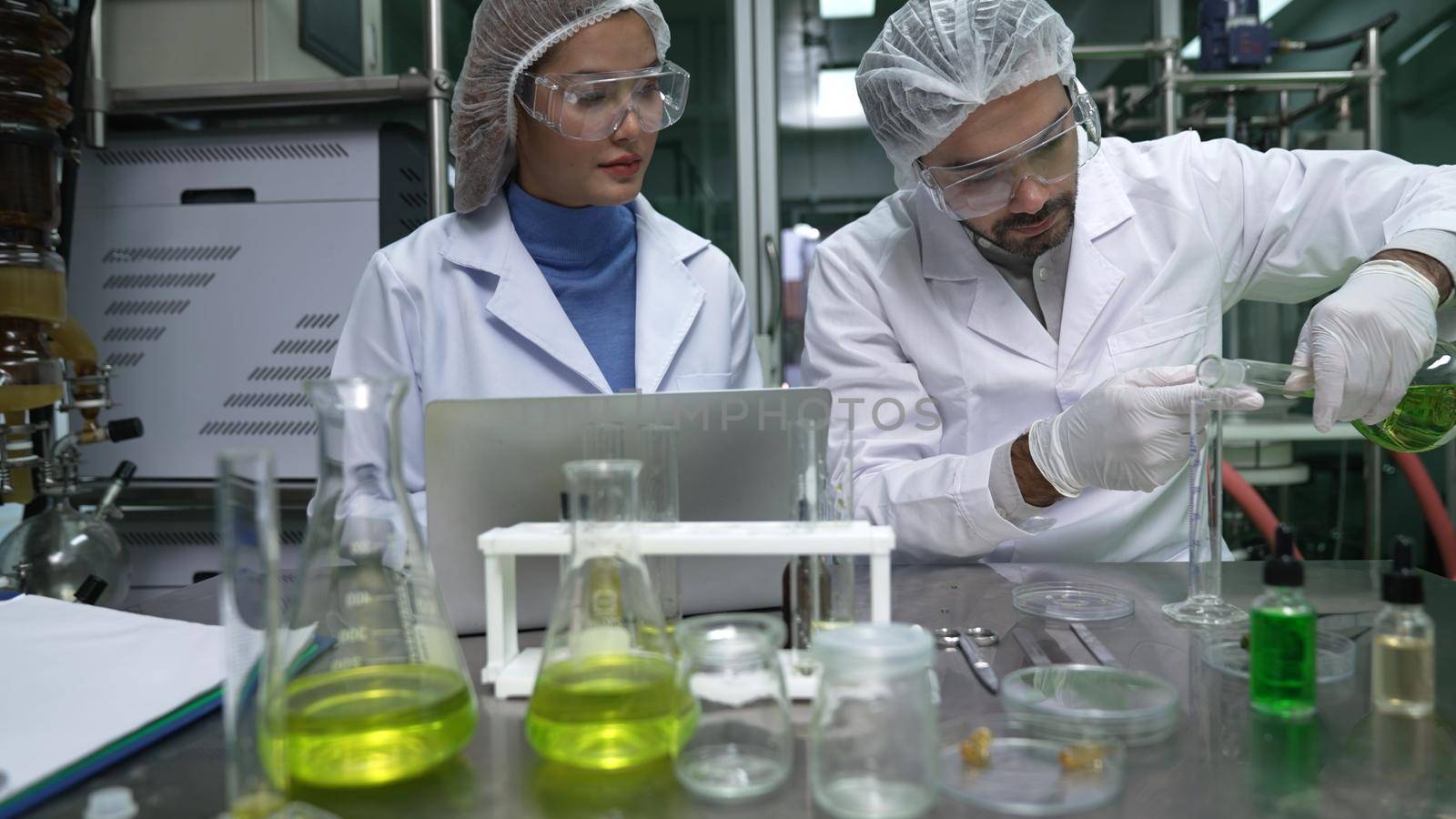 Two scientist in professional uniform working in laboratory for chemical and biomedical experiment