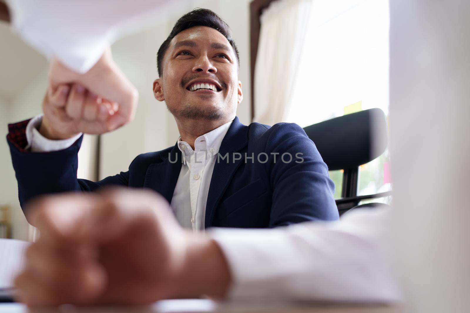 Group of business people putting their hands working together on wooden background in office. group support teamwork agreement concept by itchaznong