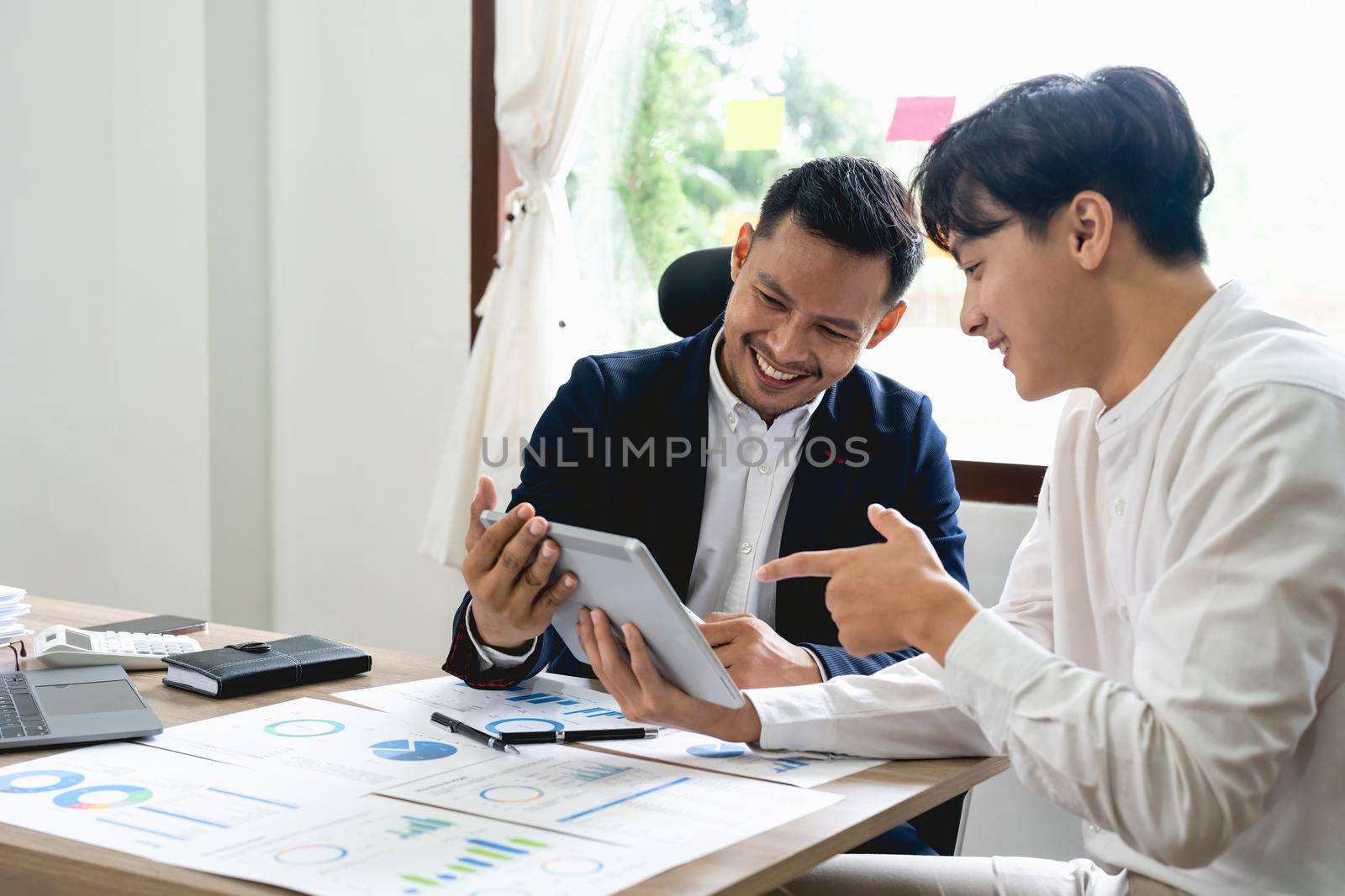 Asian business adviser meeting to analyze and discuss the situation on the financial report. Investment Consultant, Financial advisor and accounting concept