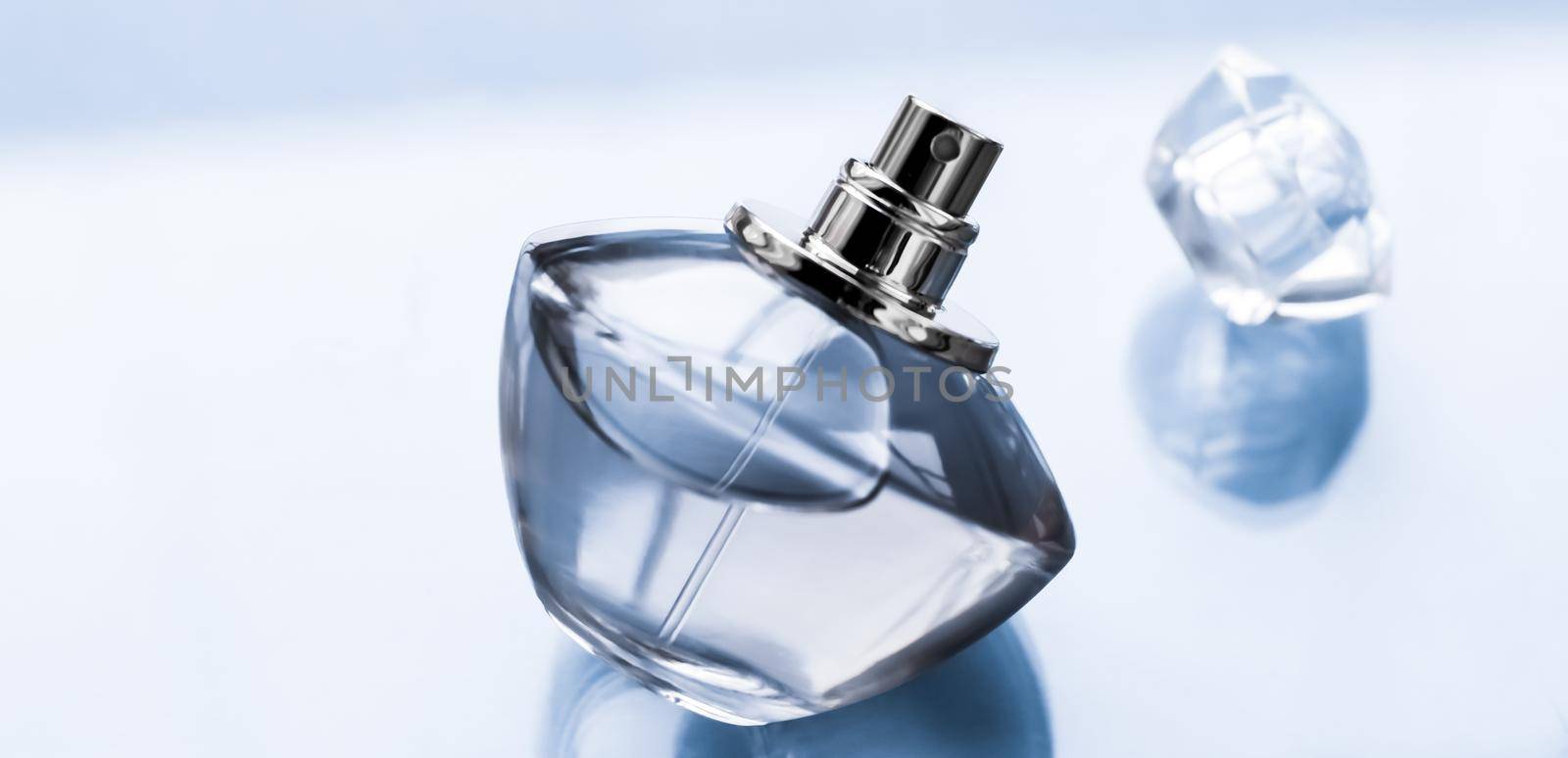 Perfumery, spa and branding concept - Blue perfume bottle on glossy background, sweet floral scent, glamour fragrance and eau de parfum as holiday gift and luxury beauty cosmetics brand design