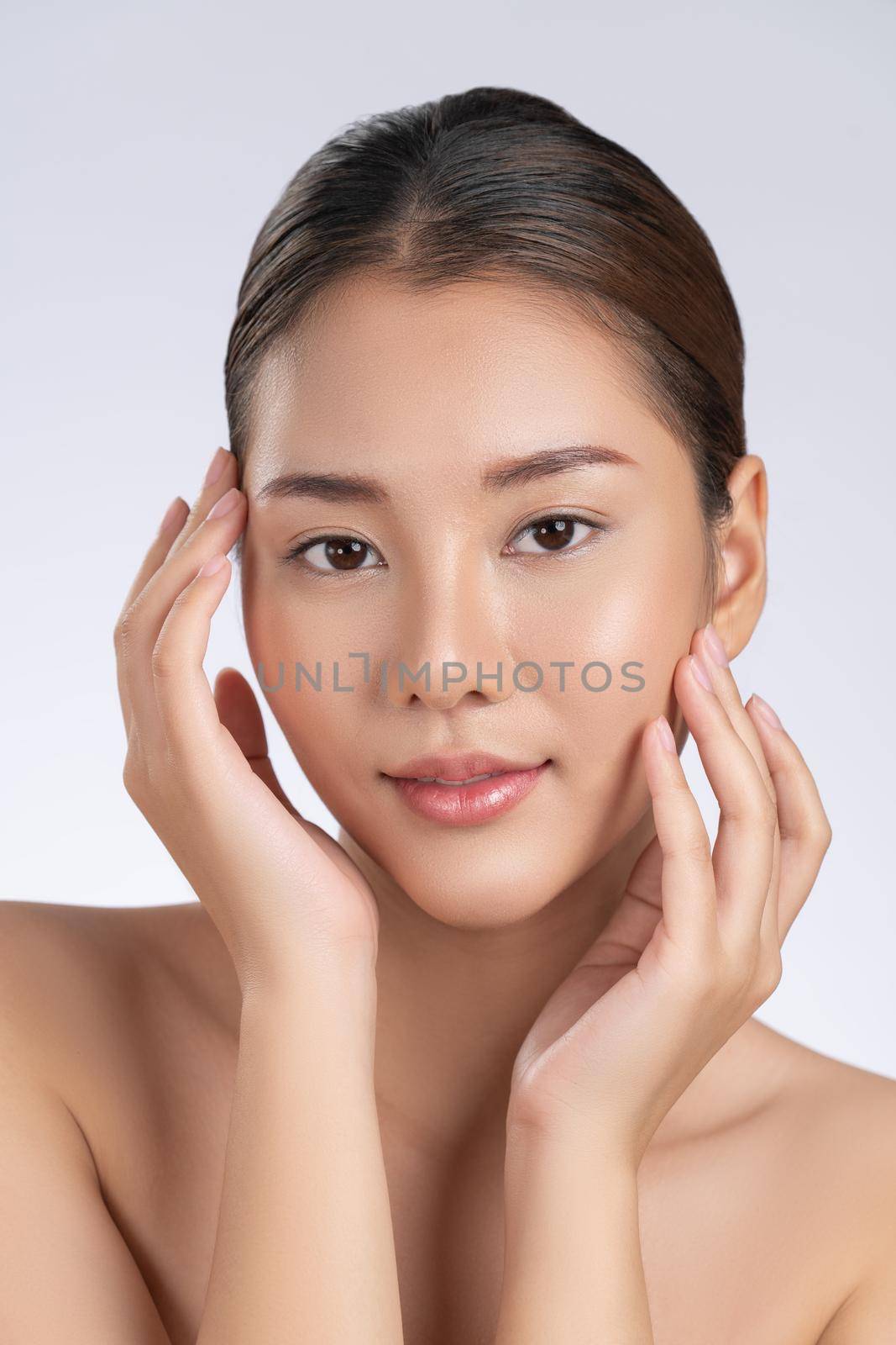 Portrait of gorgeous young girl posing beauty gesture with healthy clear skin and soft makeup. Cosmetology and beauty concept.