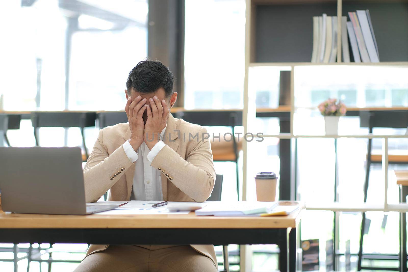 Businessmen feel stressed and tired sitting at his office with a laptop,mobbing concept.