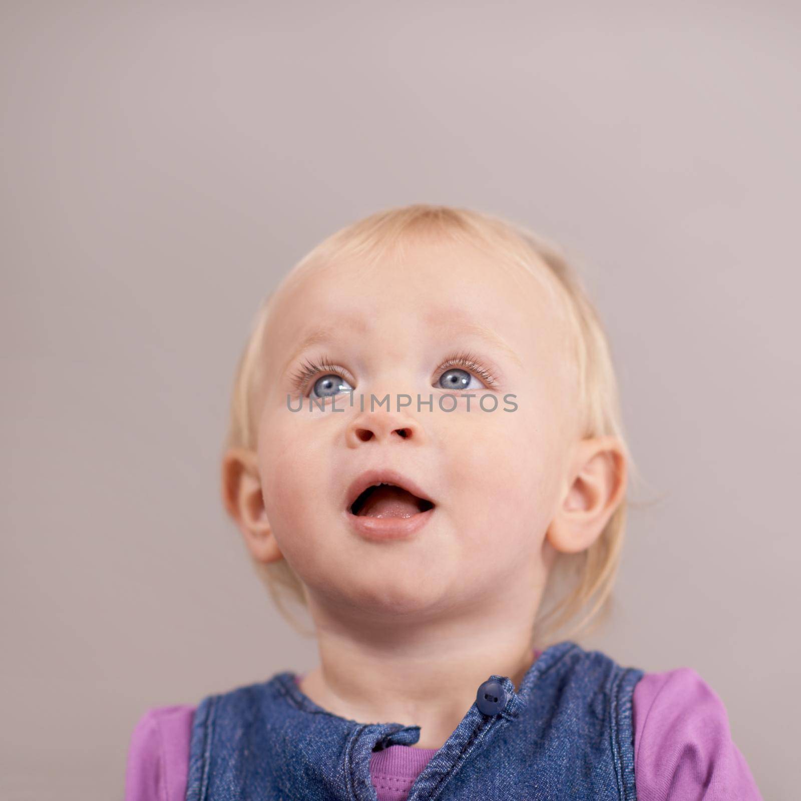 Hes such an adorable little boy. Studio shot of a baby girl looking upwards