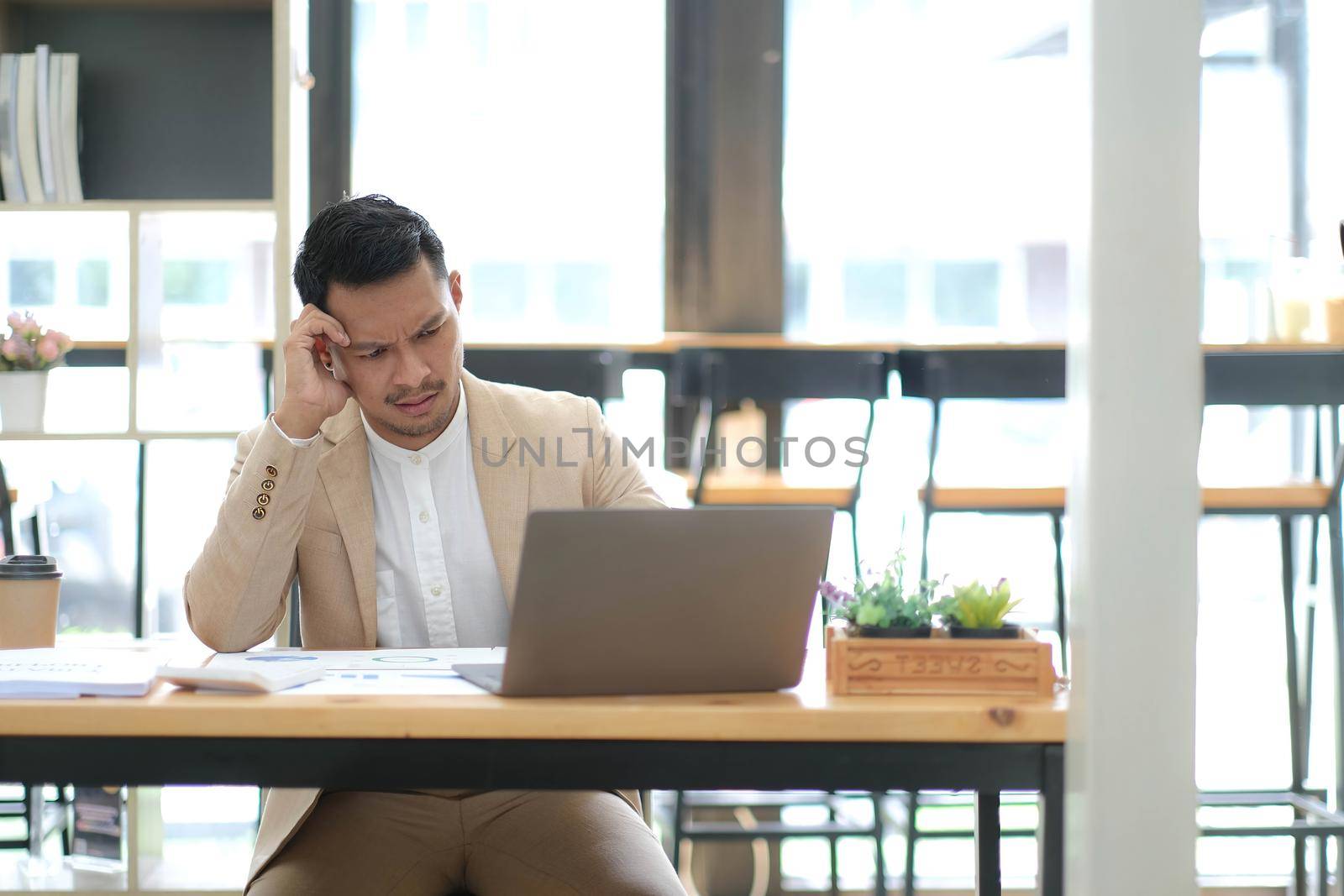 Tired frustrated young asian businessman feeling stressed holding head with hands, business problem failure concept.