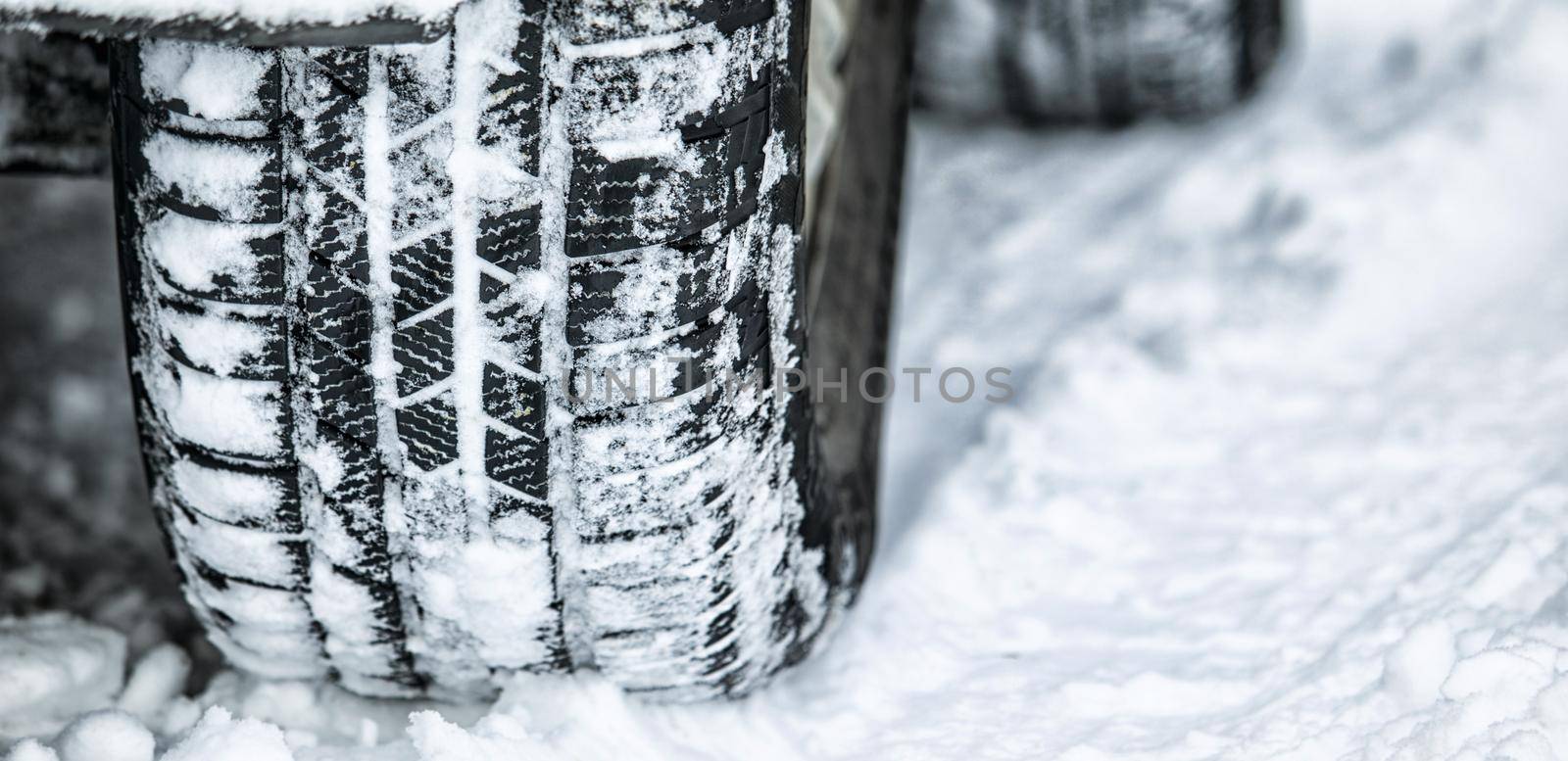 Perfect tread for a snow day. Closeup shot of a cars tyre in the snow. by YuriArcurs