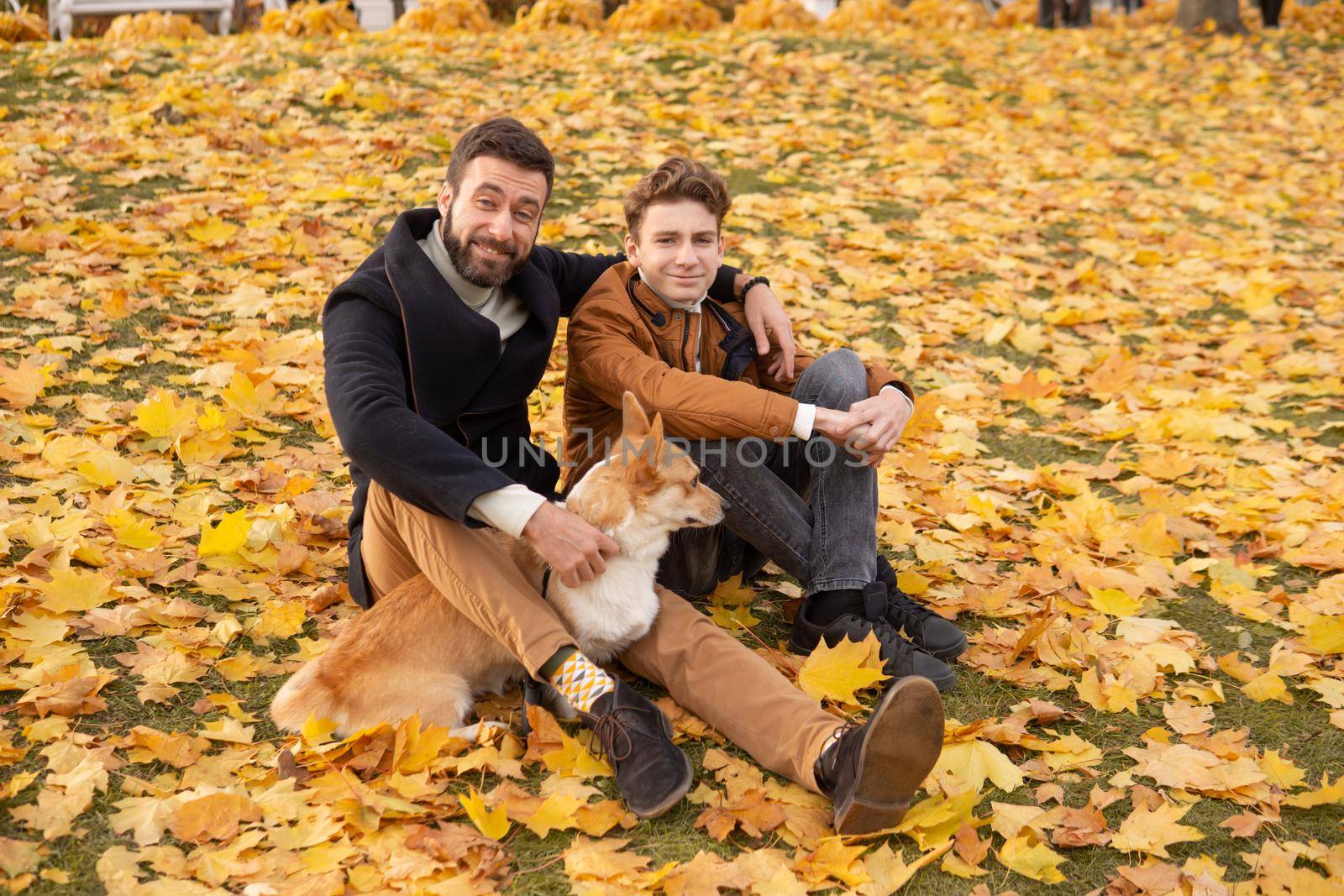 Father and son with a pet on a walk in the autumn park by Annu1tochka