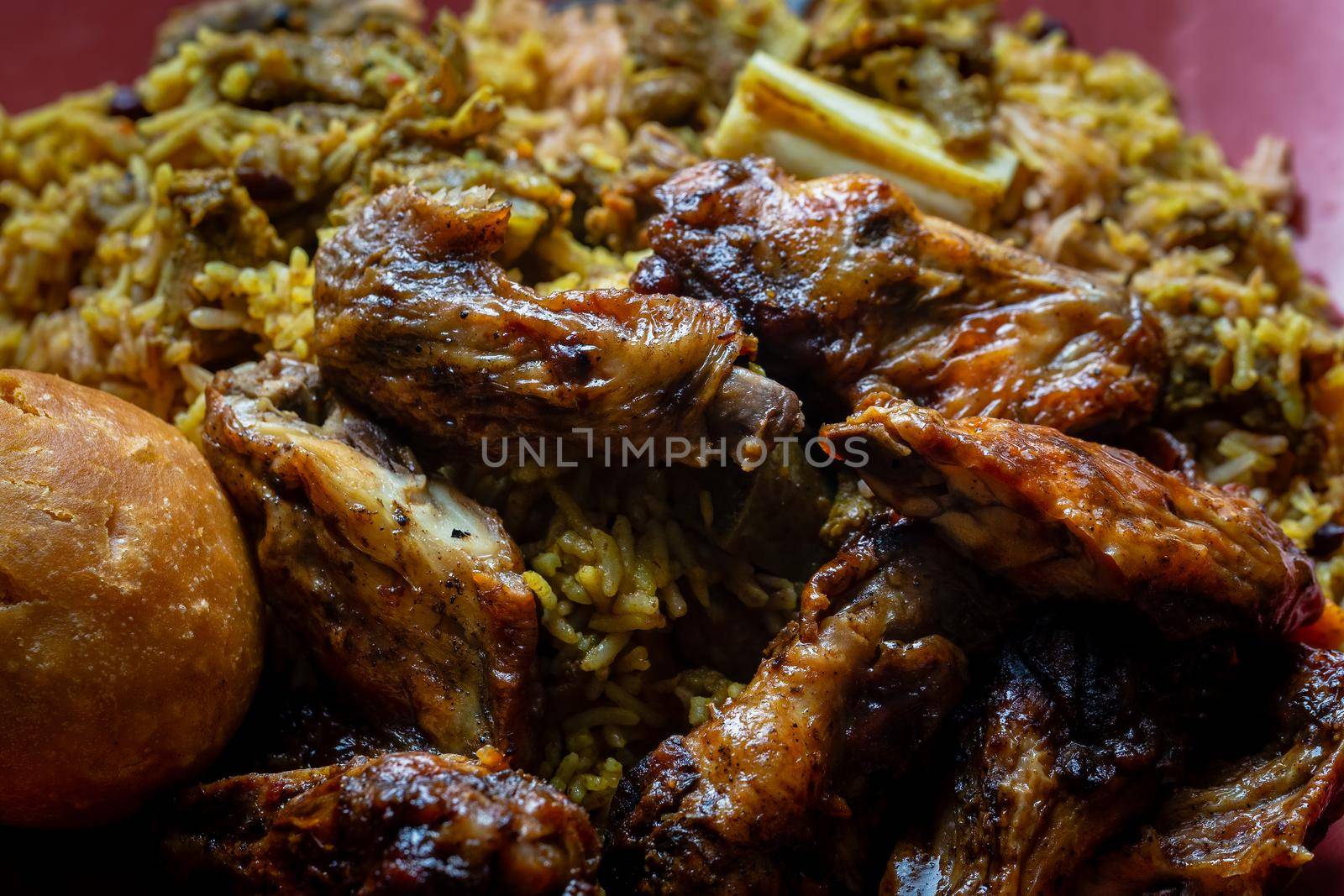 Traditional Jamaican jerk chicken wings, curried goat and fried dumpling with rice and peas