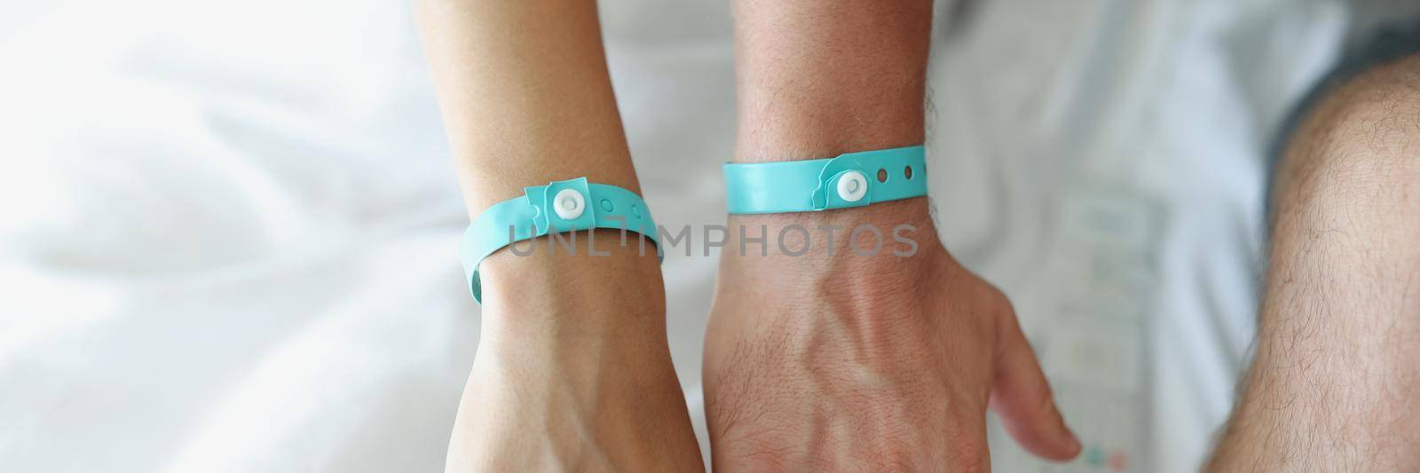 On the male and female hands a blue hotel bracelet, close-up, blurry. Loyalty program, visit to SPA and restaurant