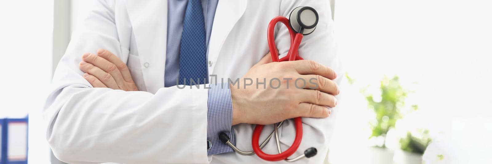 Male doctor in a white coat with a stethoscope in his hands, close-up. Consultation with a cardiologist, pulmonologist diagnosis