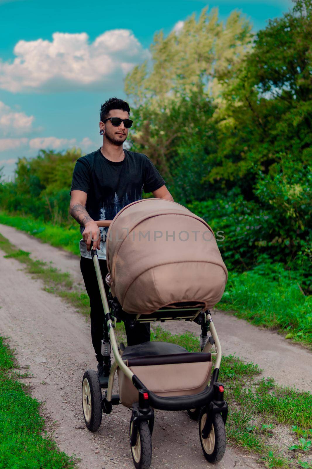 young man with stroller in the forest, summer background by banate