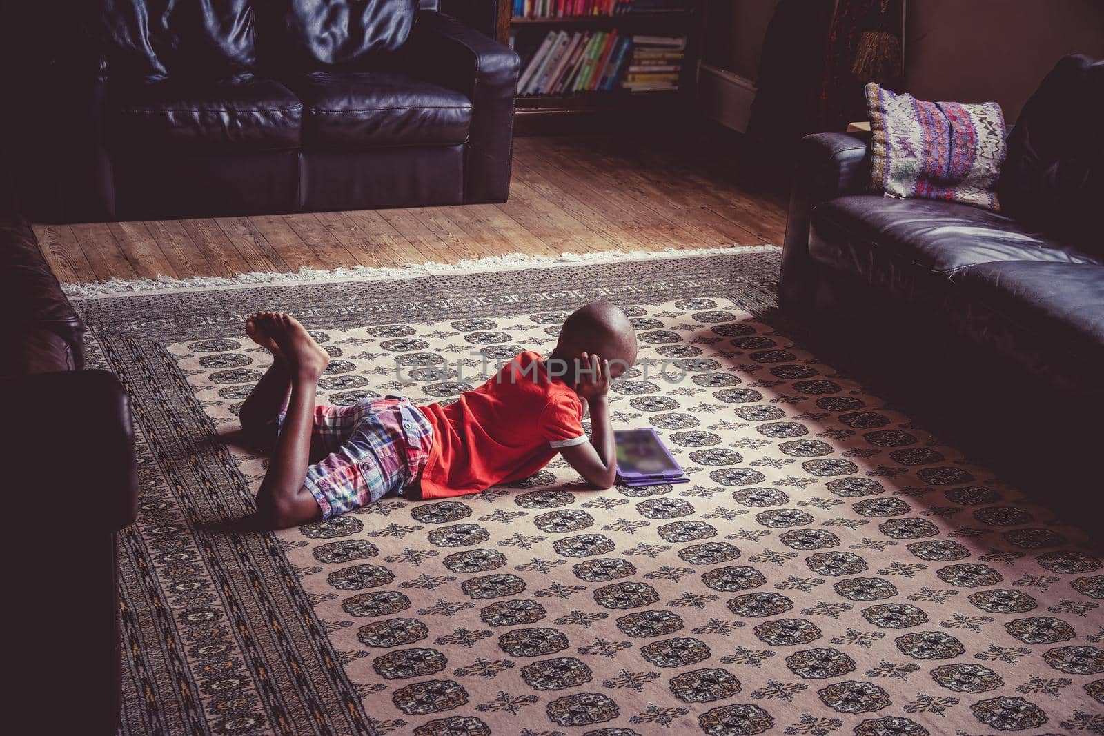 Young boy using a tablet in a relaxed home setting by magicbones