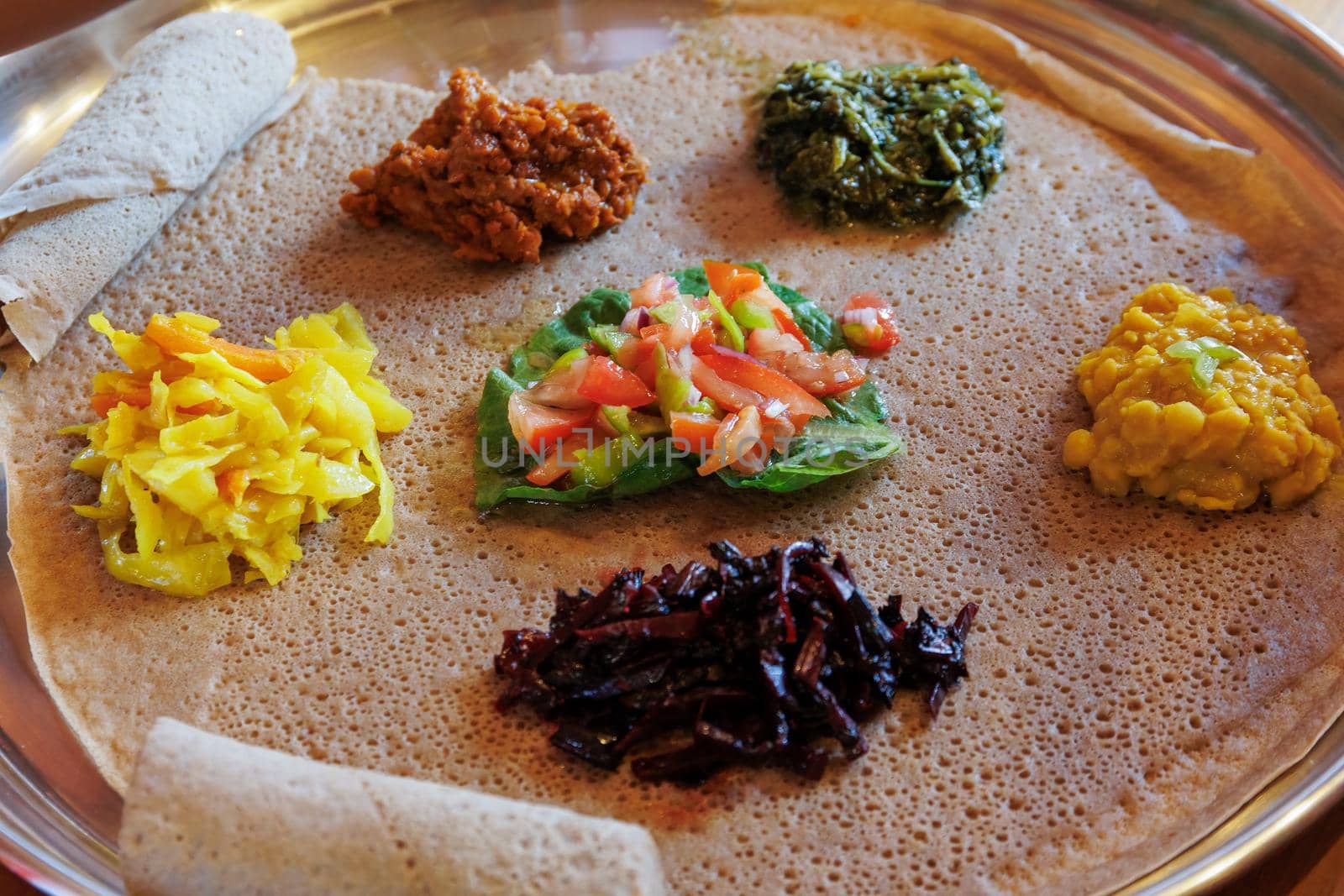Injera served with vegetables and lentils. by magicbones