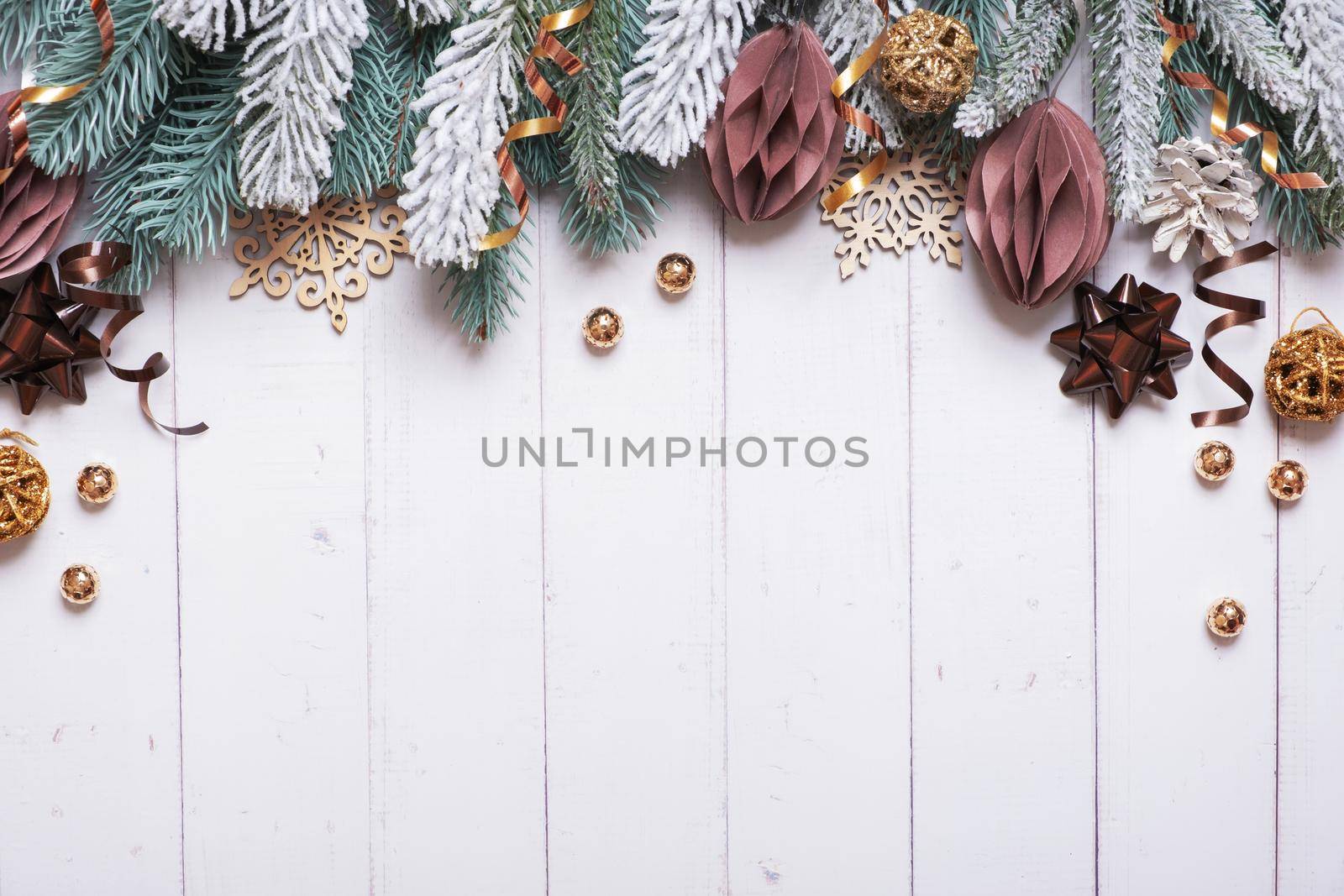 Christmas background with flat lay snow pine trees, paper and wooden Christmas toys on wooden background by ssvimaliss