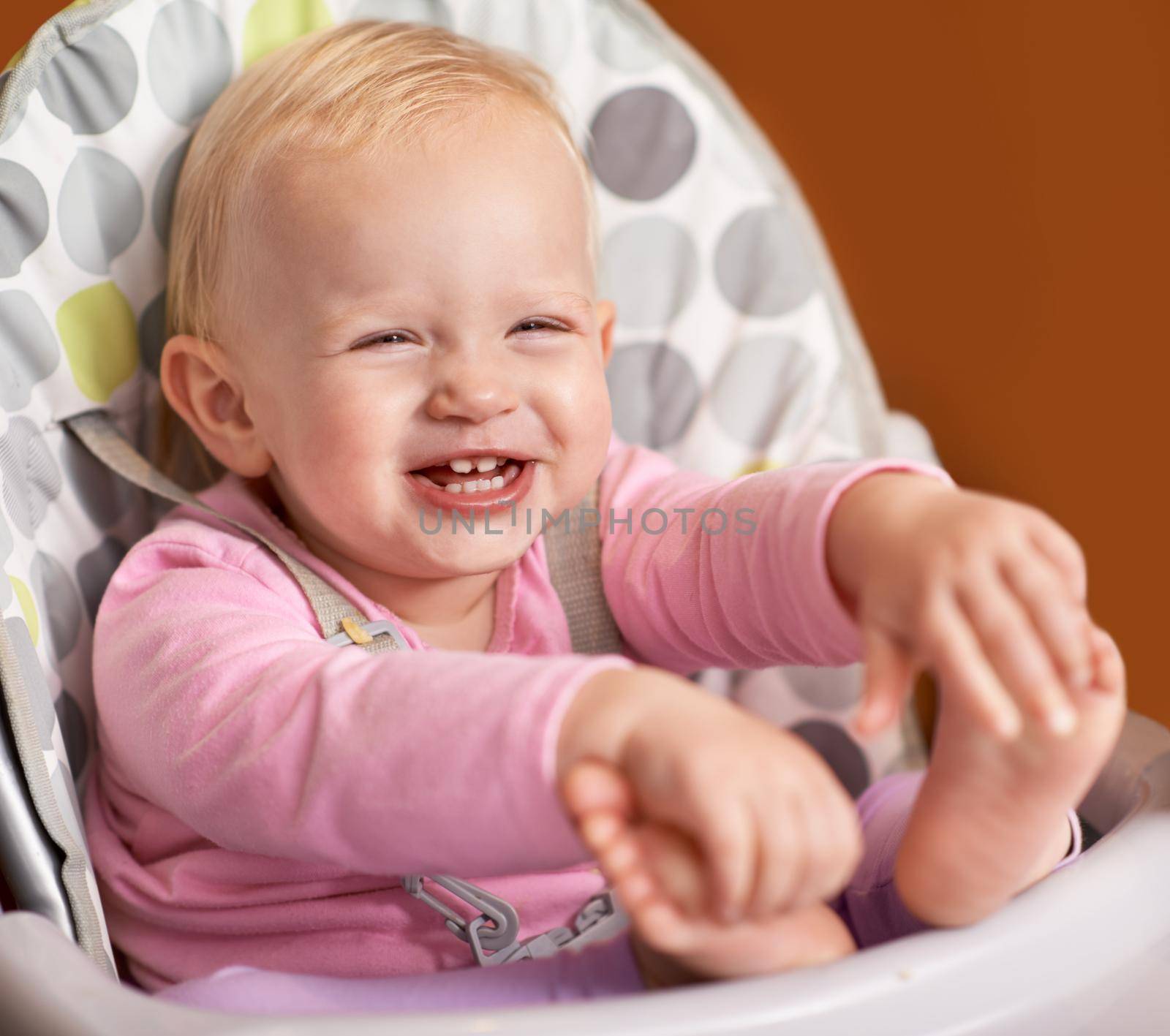 What a happy little one. Cute shot of a happy little baby in a high chair. by YuriArcurs