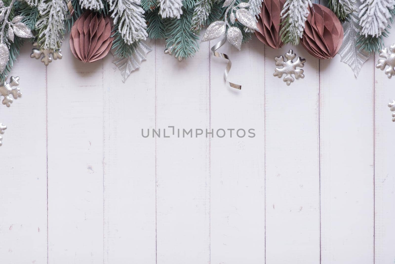 New Year Christmas flat lay with pine trees, paper Christmas toys and decorations top view on wooden background with copy space.