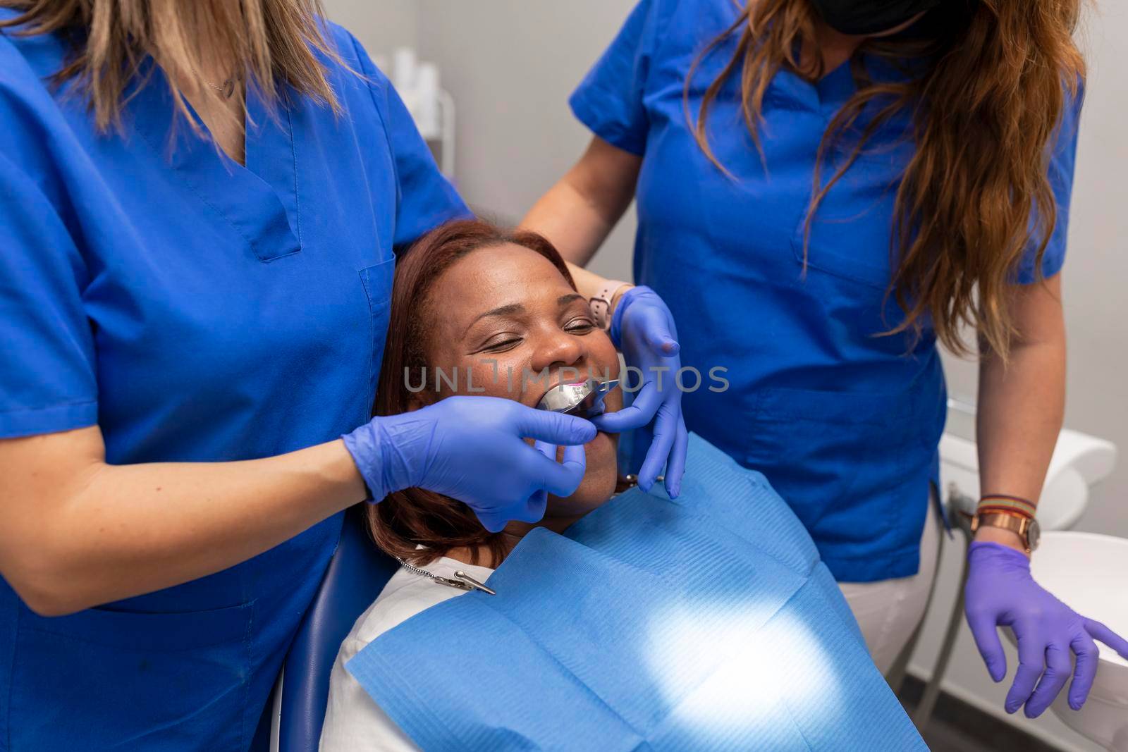 A black woman patient being put on an impression tray by stockrojoverdeyazul
