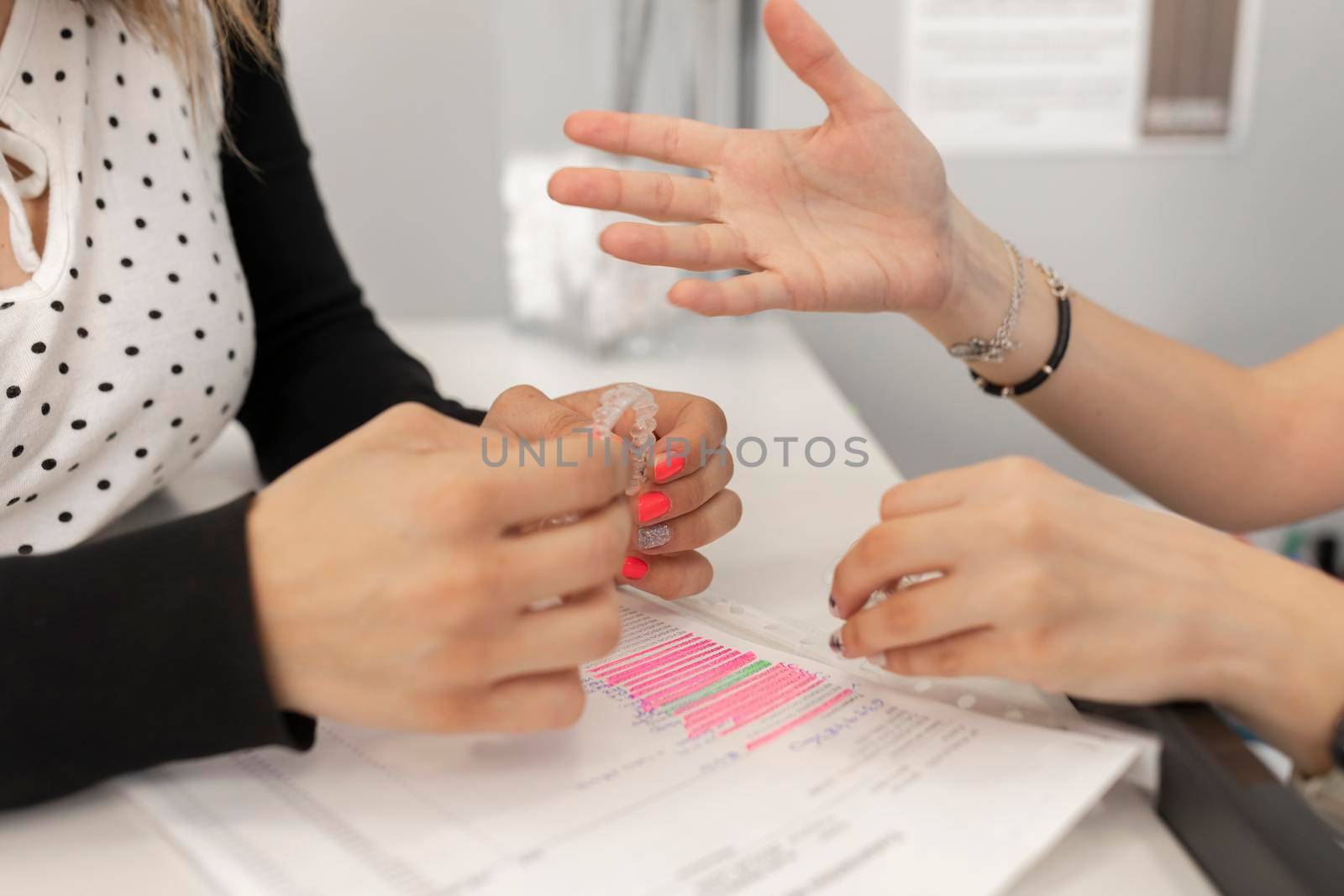 Hands of a dentist woman holding a dental splint by stockrojoverdeyazul