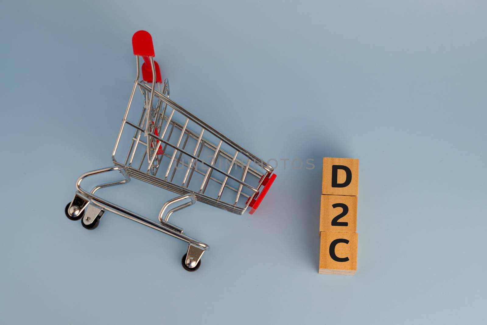 D2c direct to consumer wood cube and shopping cart on background. by aoo3771