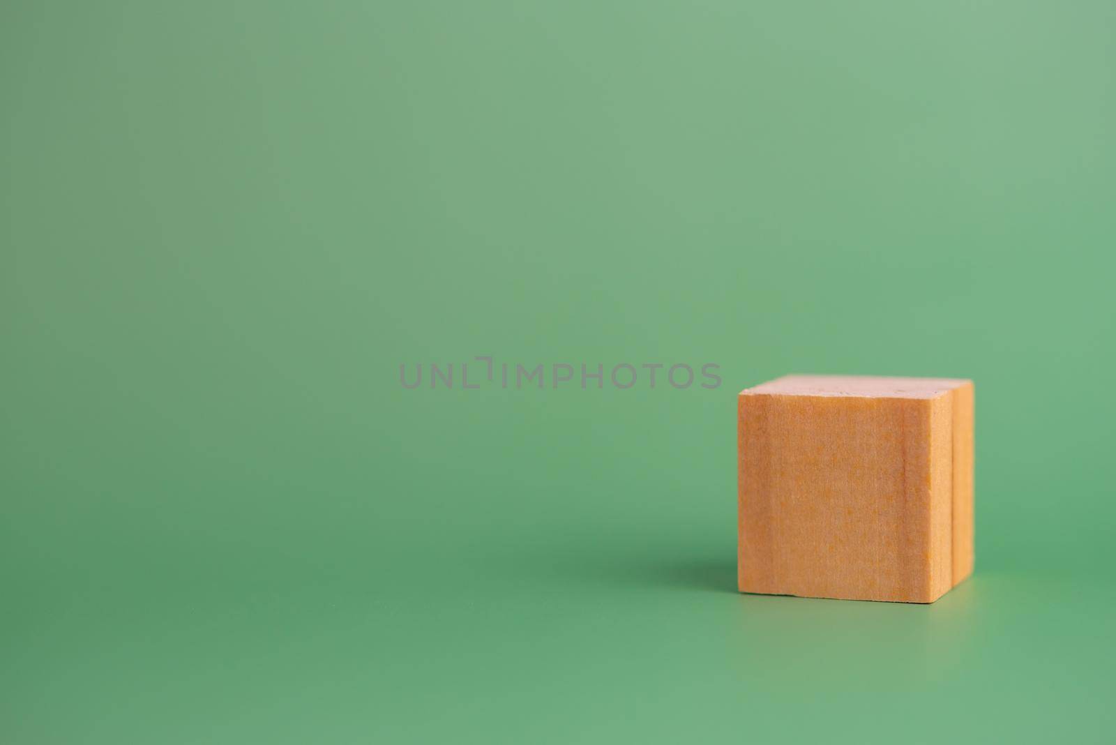 cube wood block blank on green background. copy space by aoo3771