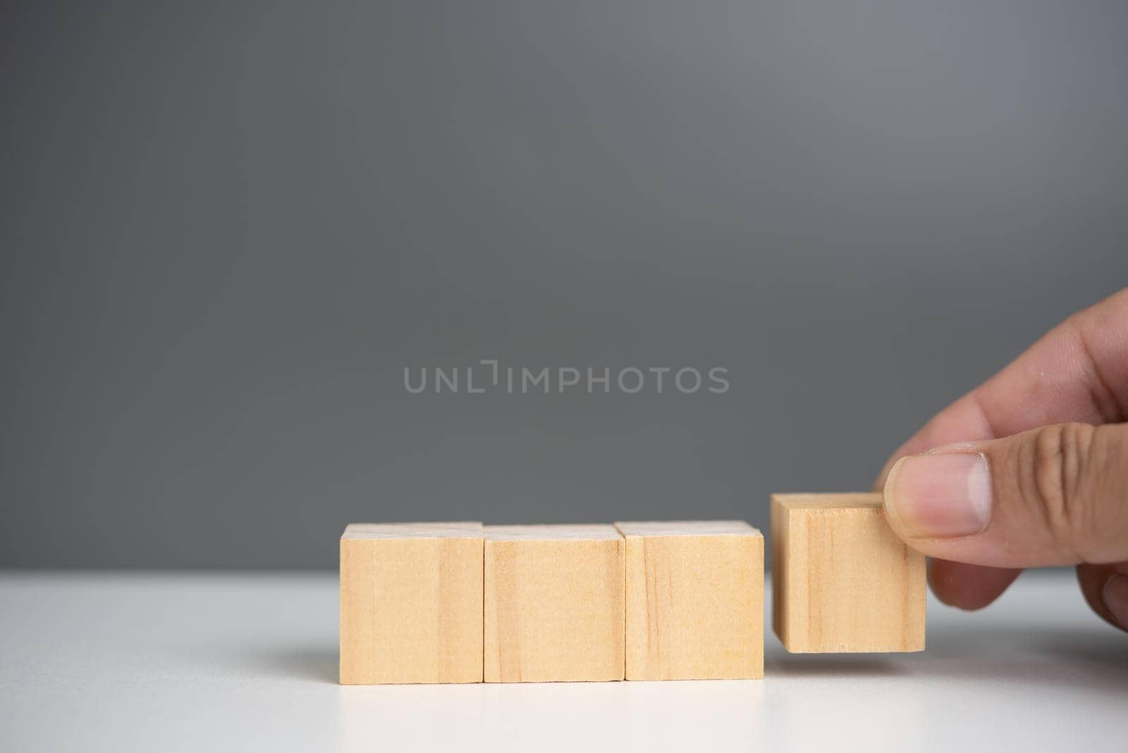 hand holding cube wood block blank on background. copy space by aoo3771
