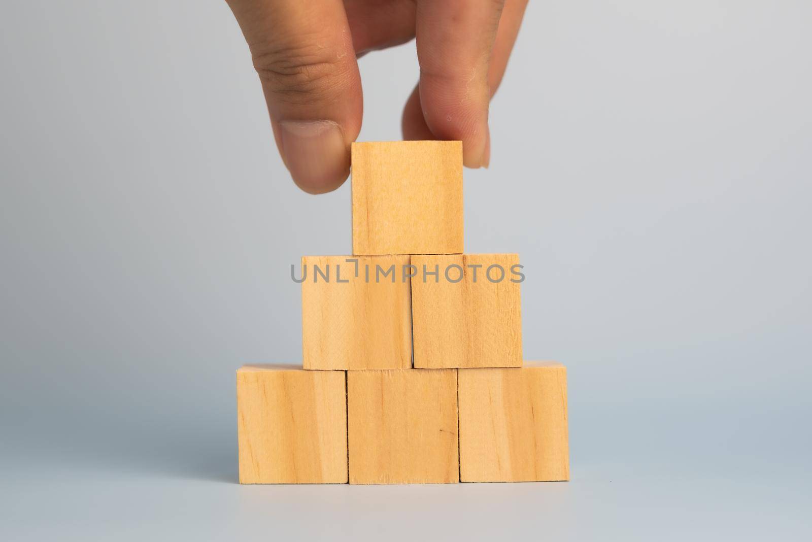 hand holding cube wood block blank on background. copy space by aoo3771