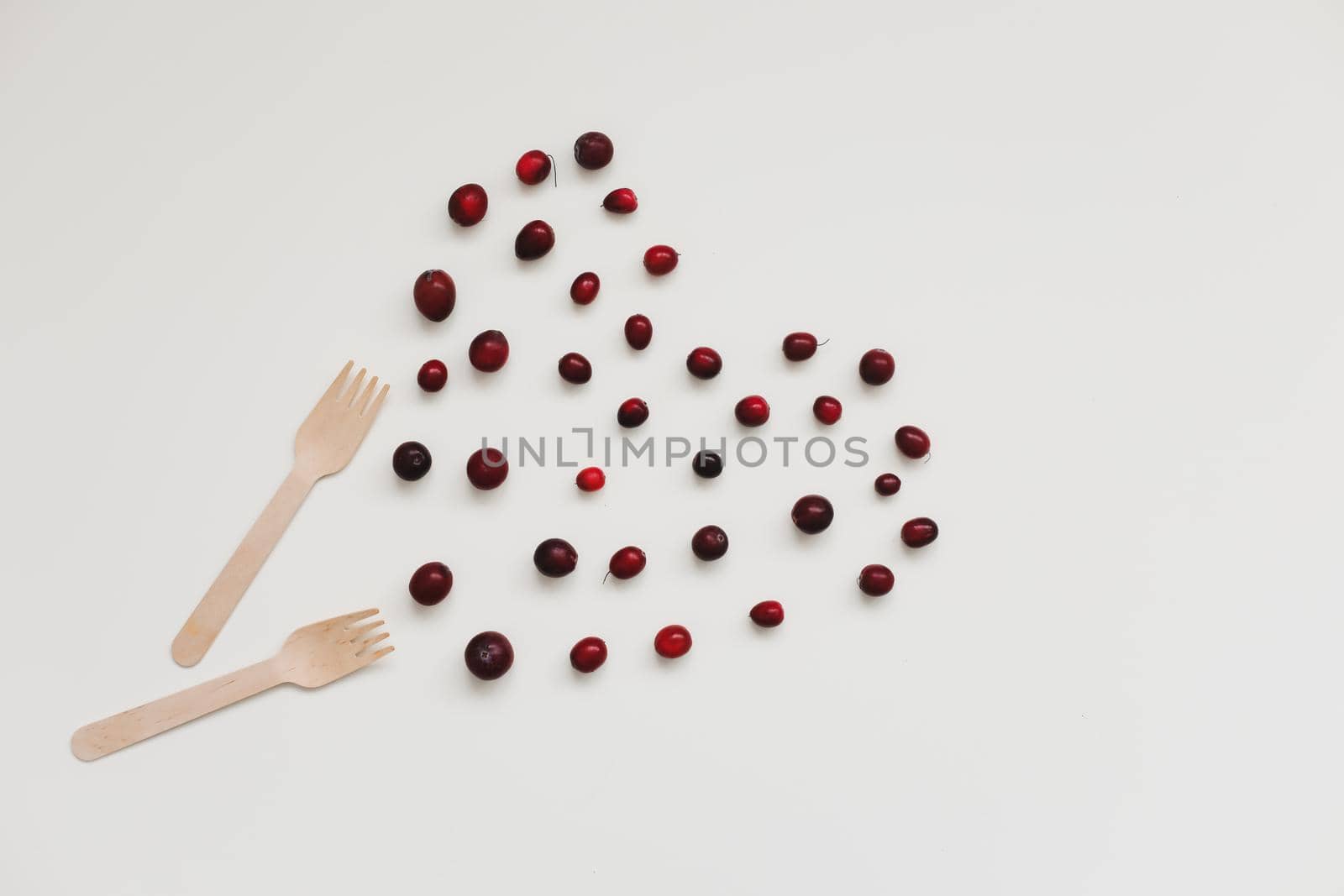 wood fork, bamboo cutlery and berries on white background, zero waste, no plastic, eco-friendly, vegan food concept.