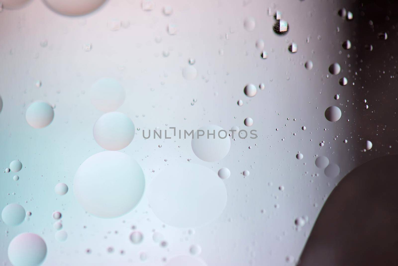 Defocused pastel and dark colored abstract background picture made with oil, water and soap by anytka