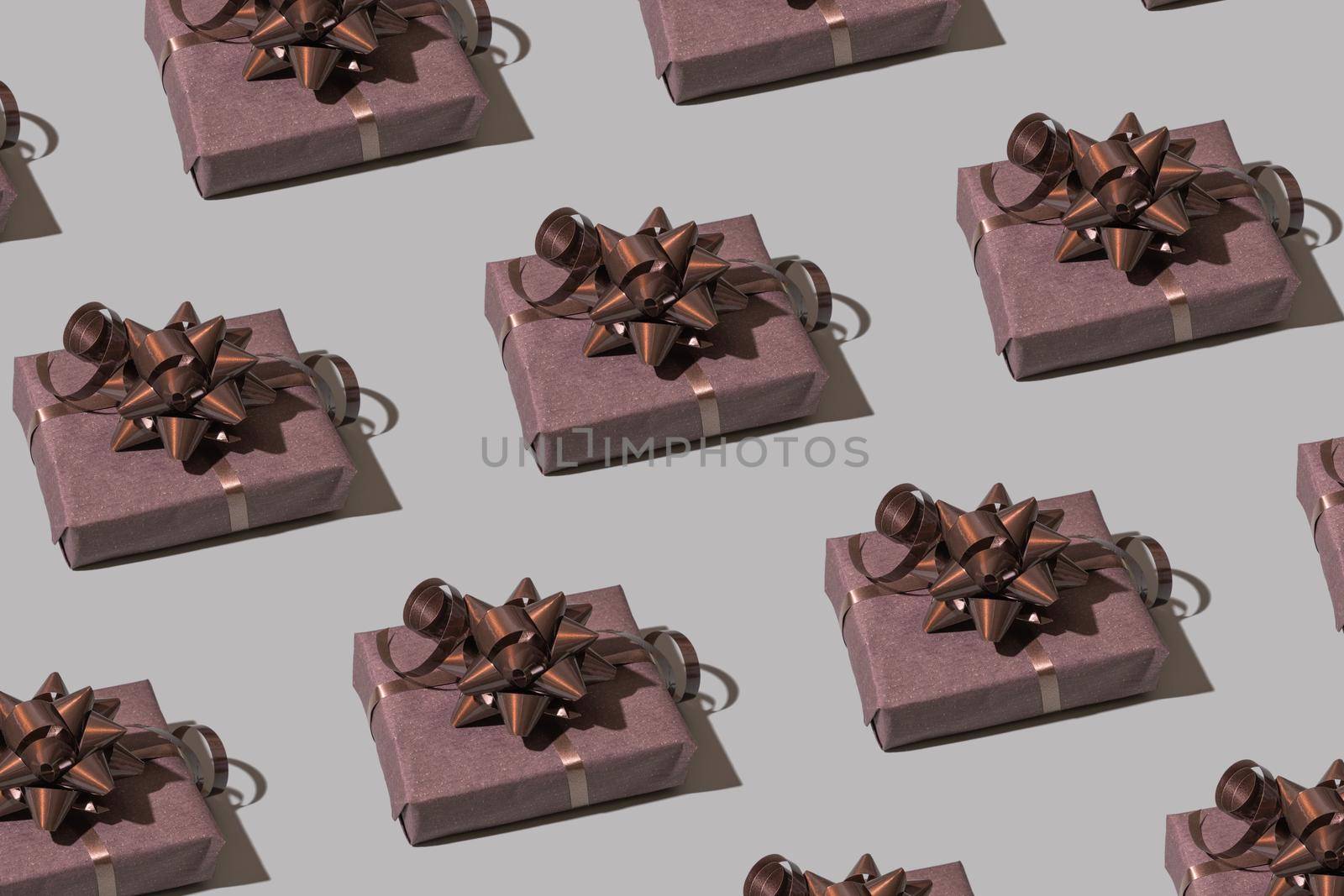 Brown gift box pattern with bow on gray background. Christmas minimalist concept photo by ssvimaliss