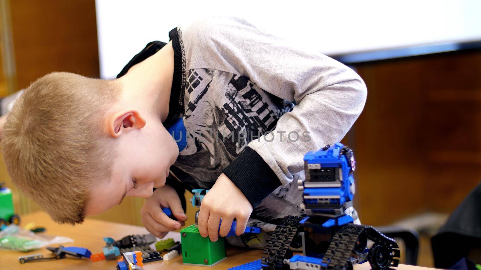the boy of 10 years, plays in the designer from cubes, plates, circuits, wires. a small inventor creates robots, machines from different parts of the designer. children are fond of robotics, programming, modeling,. High quality photo