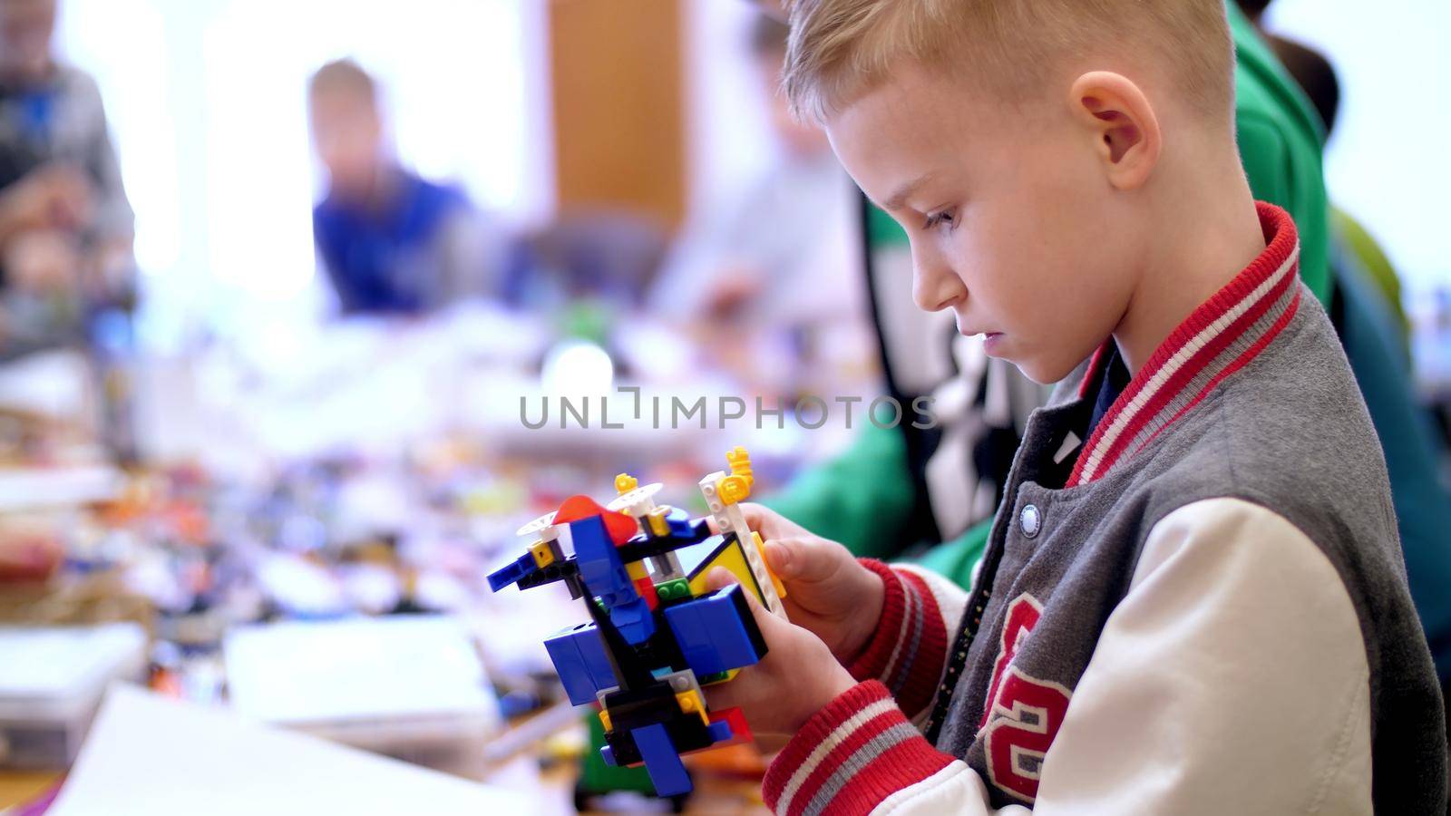 the boy of 10 years, plays in the designer from cubes, plates, circuits, wires. a small inventor creates robots, machines from different parts of the designer by djtreneryay