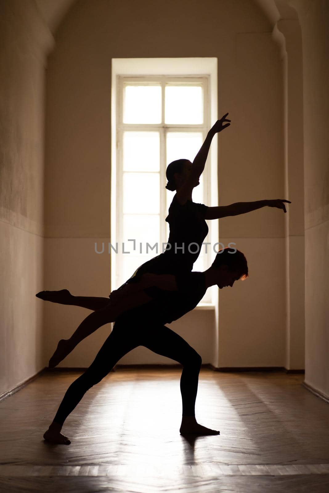 Silhouettes of girl and boy dancing ballet.
