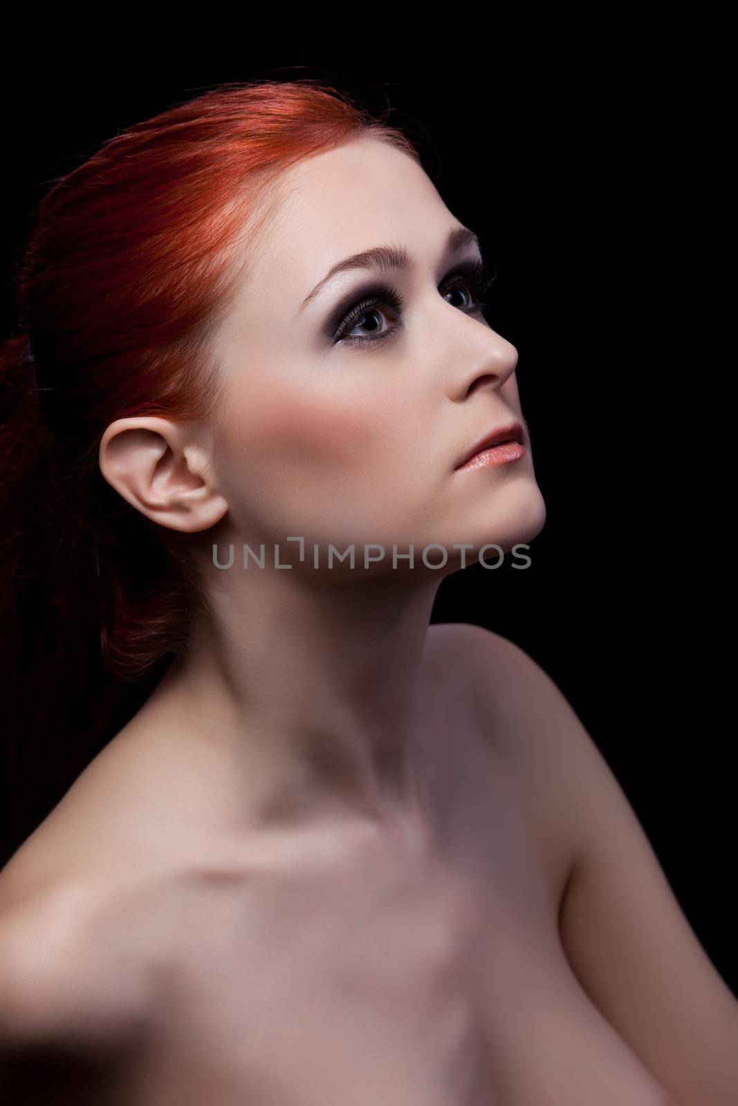 Portrait of beautiful woman with red hair. Isolated on black