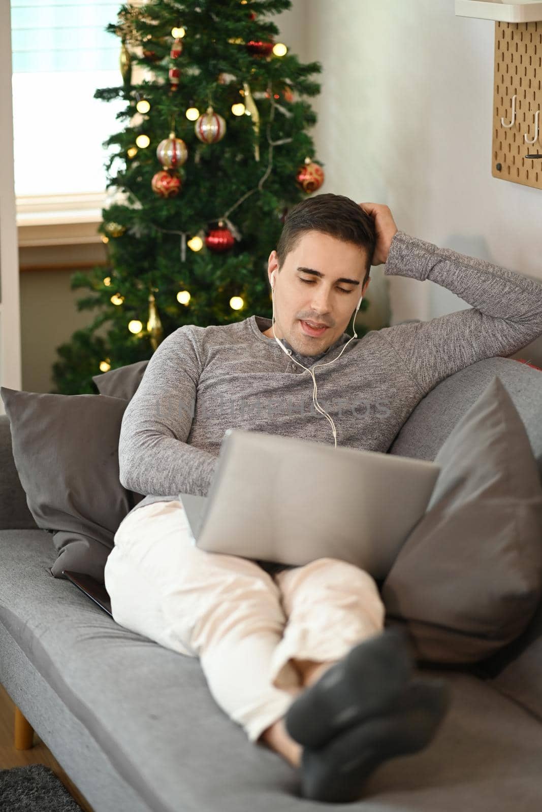 Casual man sitting on comfortable sofa and using laptop computer. by prathanchorruangsak