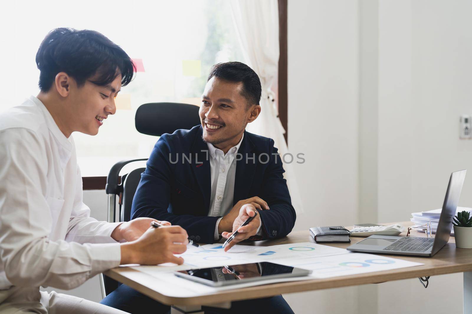 Asian business adviser meeting to analyze and discuss the situation on the financial report. Investment Consultant, Financial advisor and accounting concept
