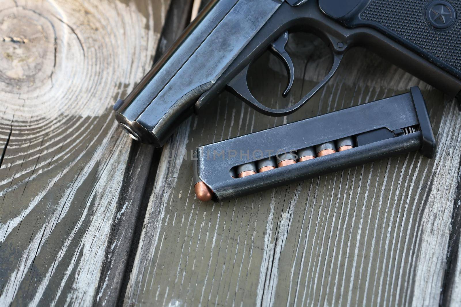 Handgun cartridges closeup on old wooden background near pistol
