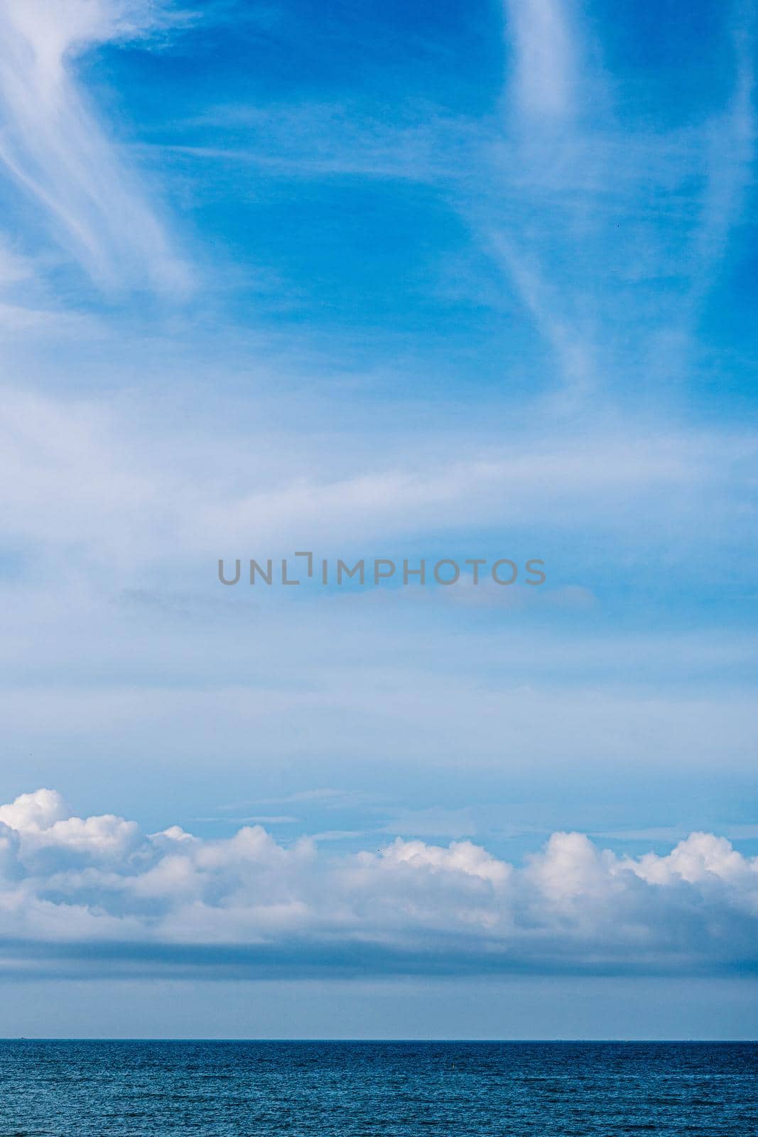 Atmosphere VERTICAL panorama real photo beauty nature wallpaper. Fantastic sky view clouds cumulus cirrus stratus sea horizon line. Wallpaper design background like painted fairy tale mood.