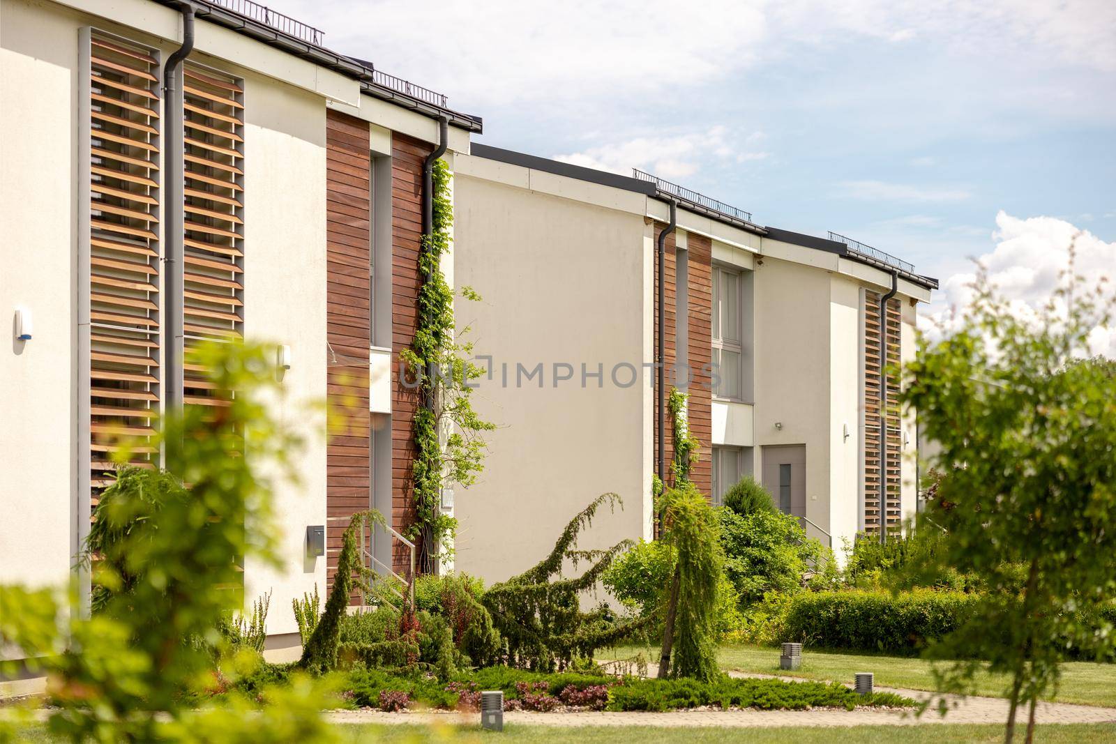 Row of modern cottages. Brand new row of single family houses. Modern design of urban living residences with private courtyards, sophisticated finishes. New development. Green outdoor facilities, lawn