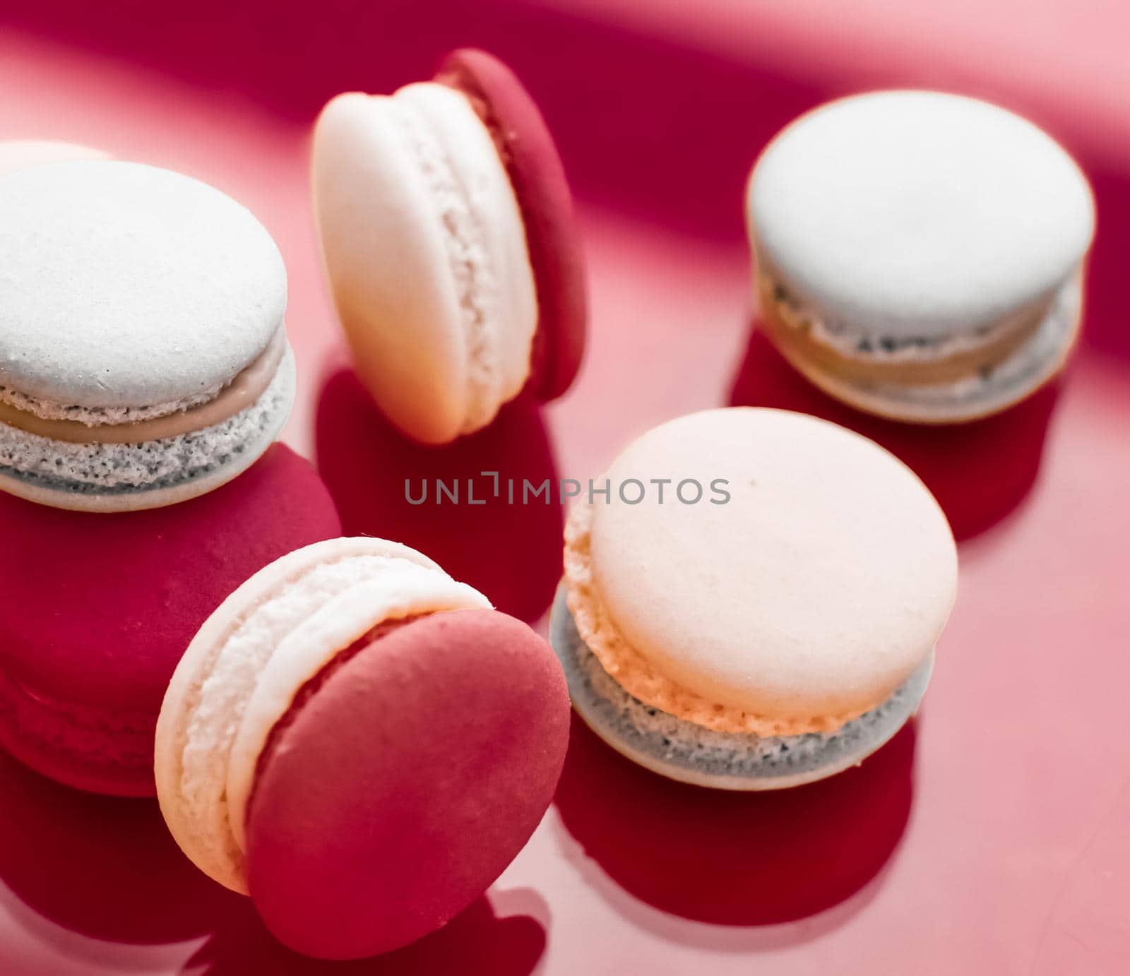 French macaroons on wine red background, parisian chic cafe dessert, sweet food and cake macaron for luxury confectionery brand, holiday backdrop design by Anneleven