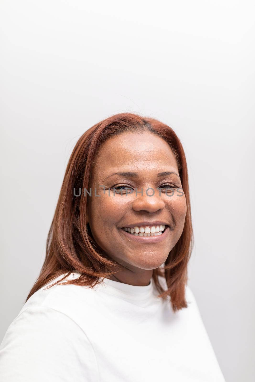 A black woman smiling and posing in the waiting room of the dental clinic where she gets usually treated