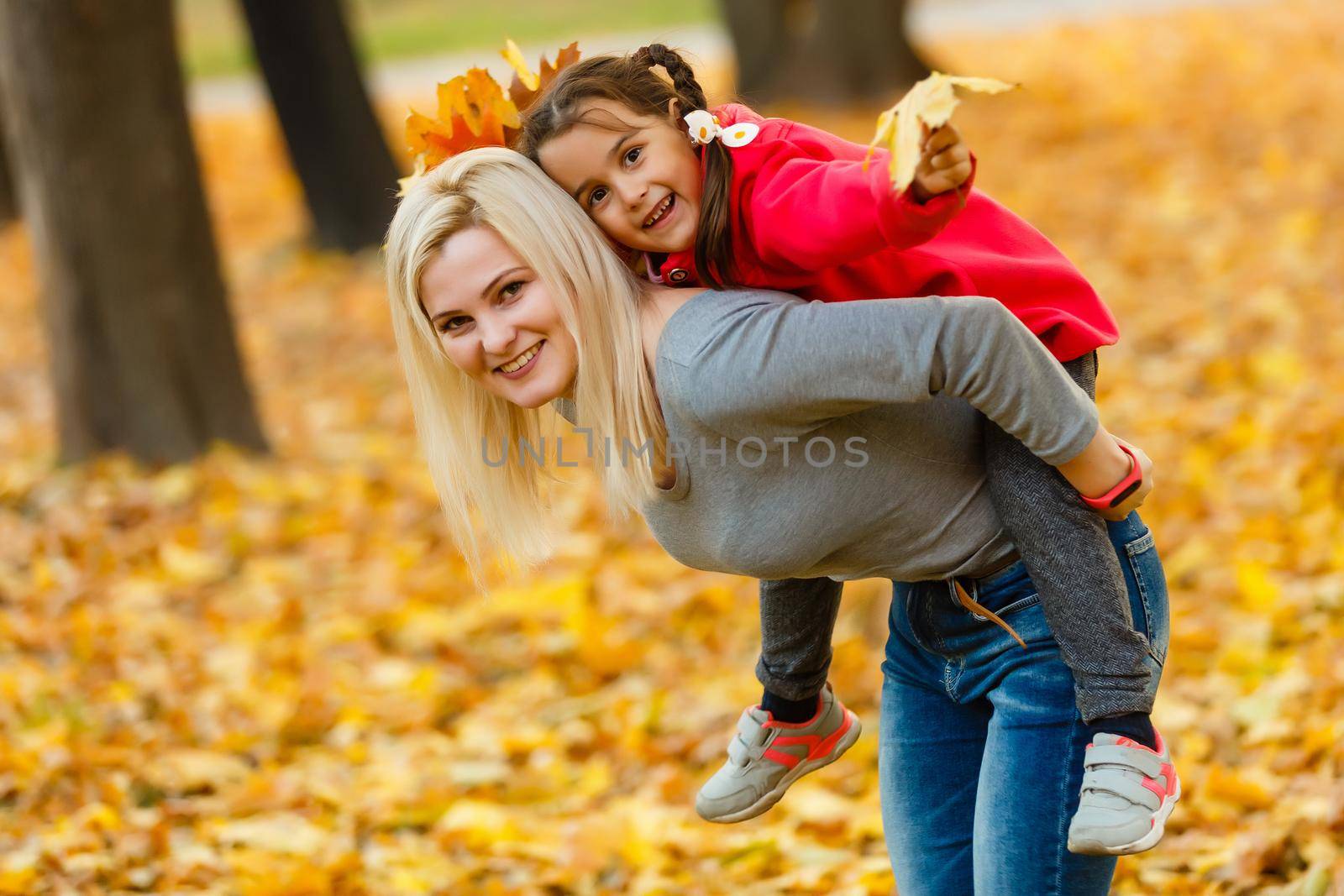 happy family mother and child daughter playing and laughing on autumn walk