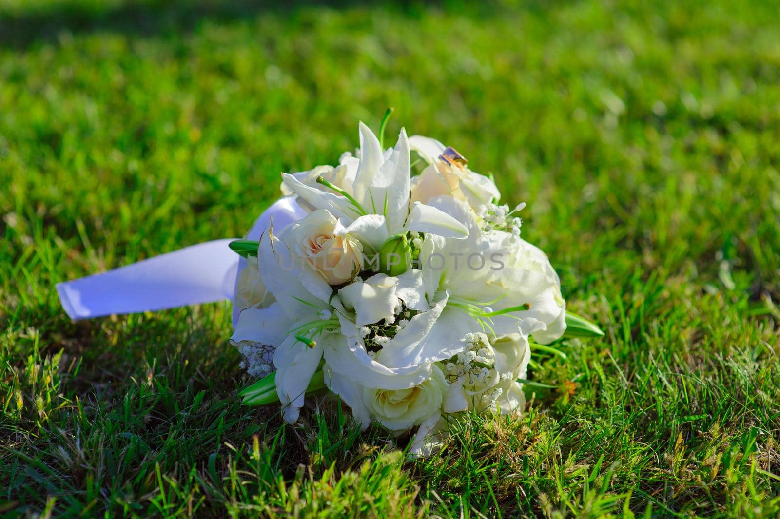 Bridal wedding bouquet of flowers. Wedding bouquet of yellow and white roses lying on a grass