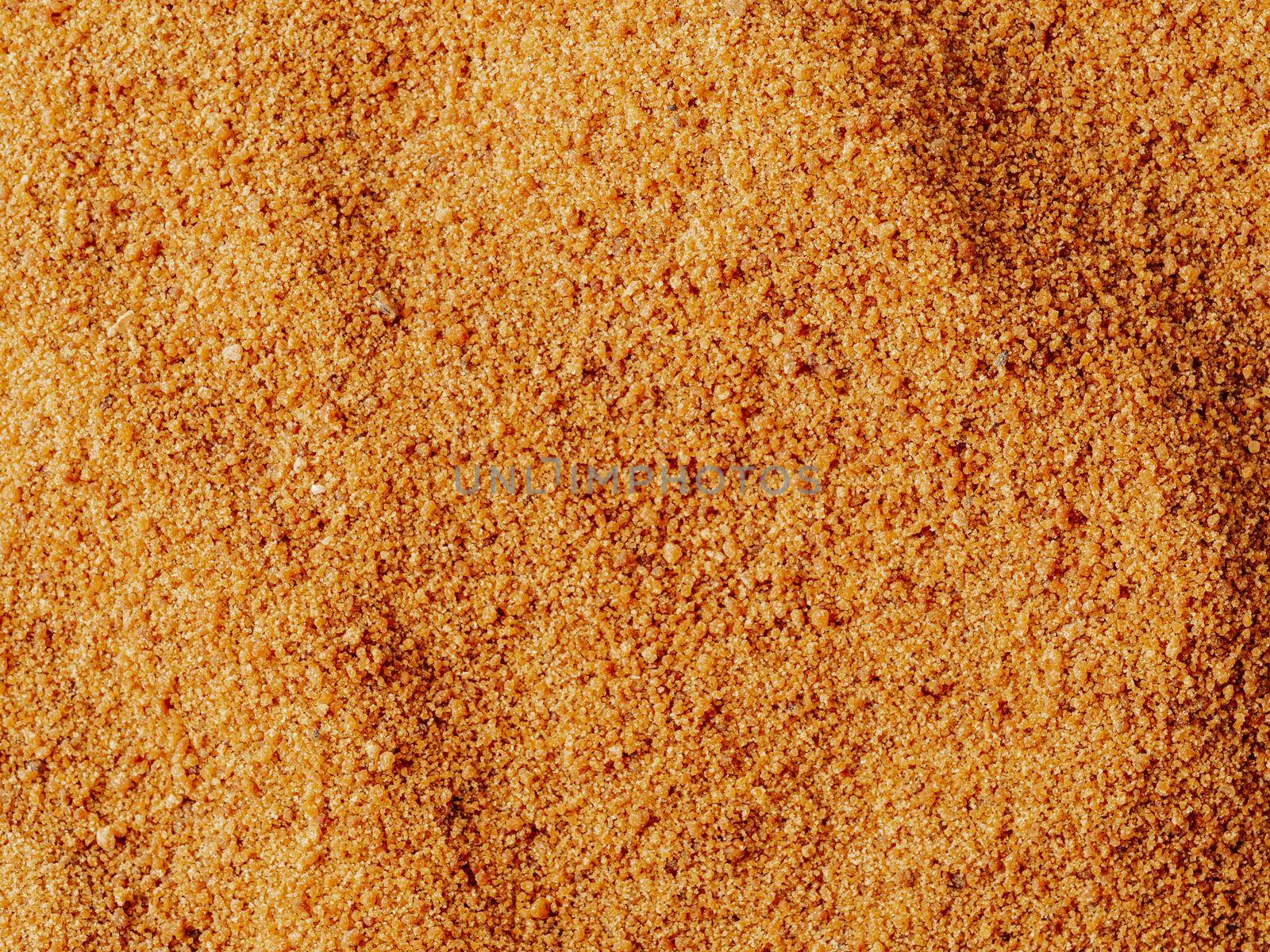 Background texture of raw organic coconut sugar from crystallized sap of cut flower buds coconut palm. Brown coconut palm sugar background topview. Alternative healthier low glycemic index sweetener