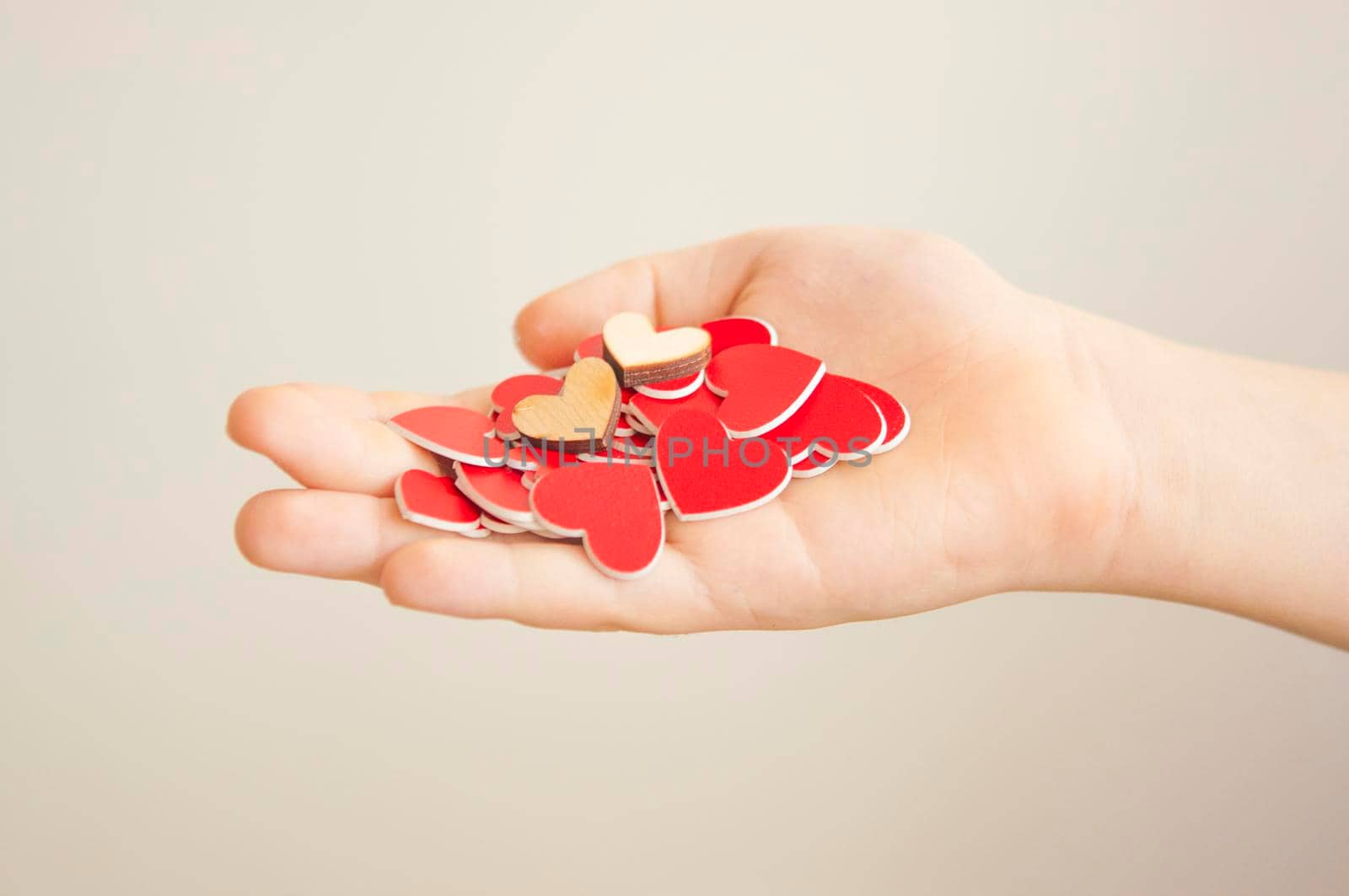 hands hold a many red hearts on white background