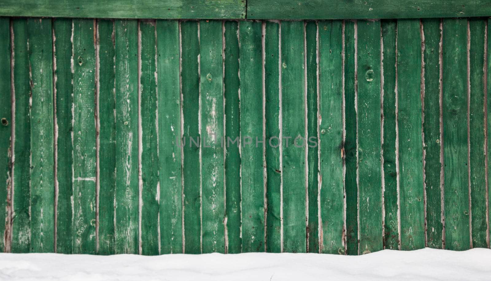 Old fence with cracked green paint wooden background texture