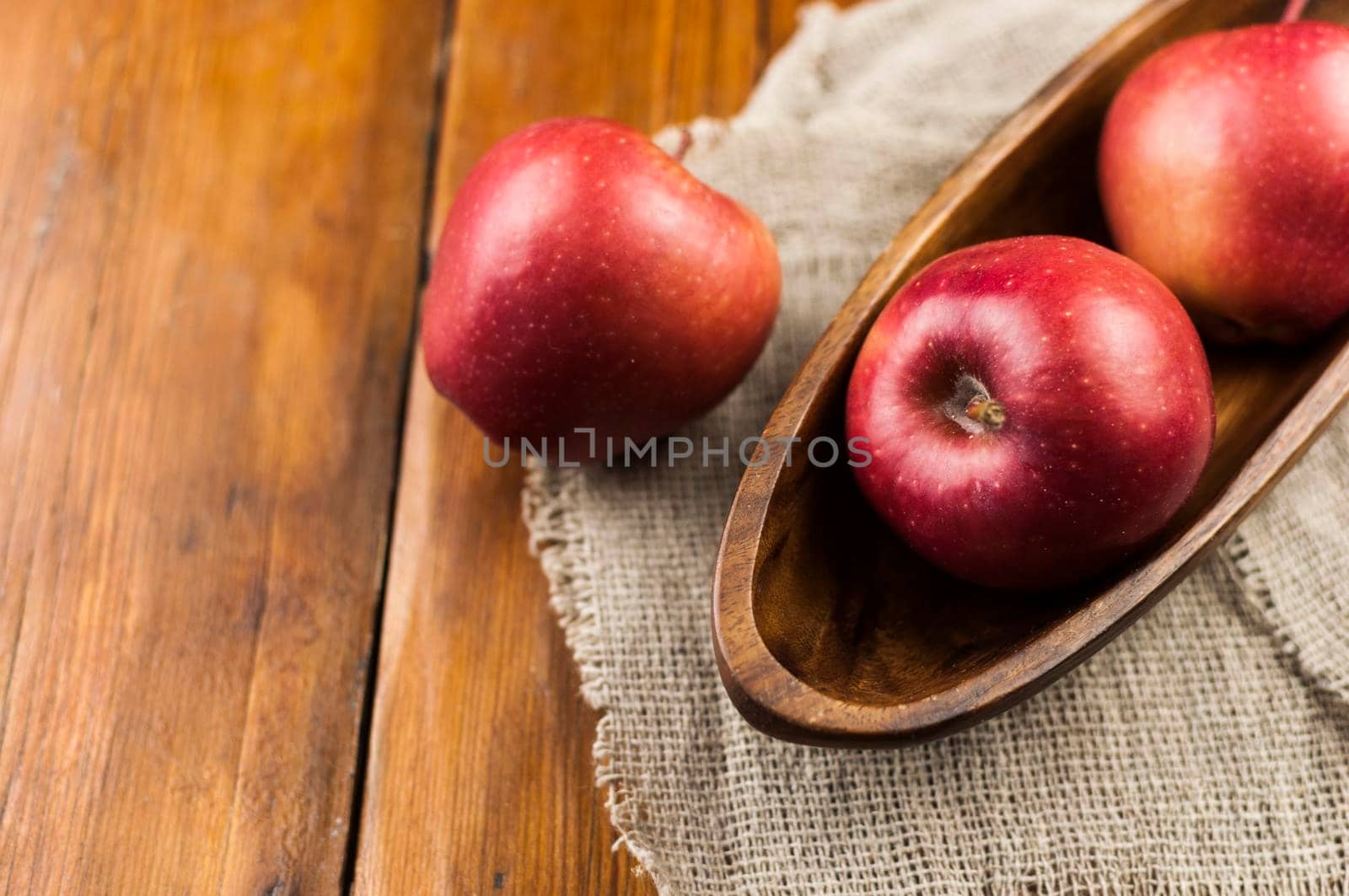 red ripe organic healthy apples in bowl on wooden board. Healthy food