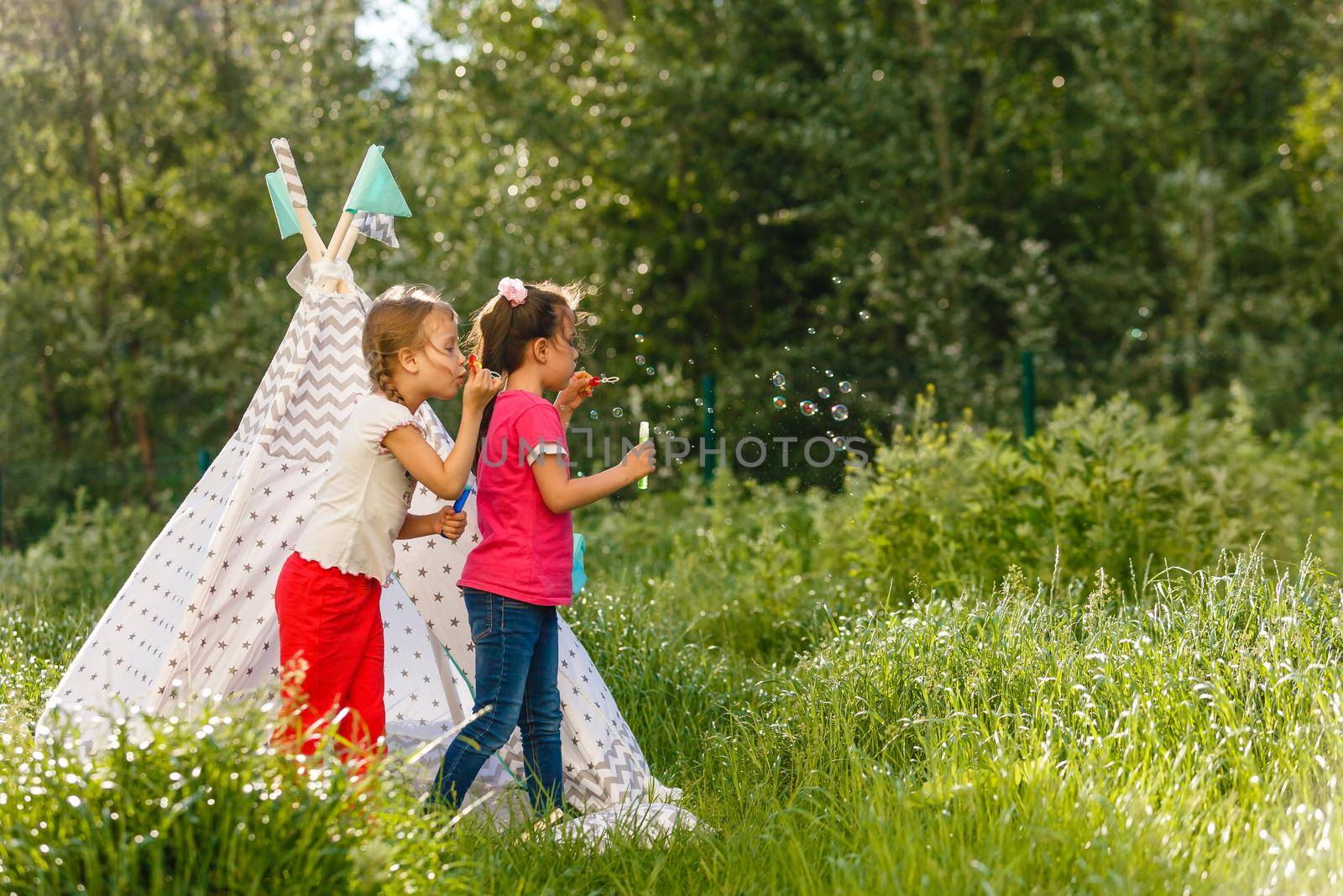 Adorable little girls having fun playing outdoors on summer day by Andelov13