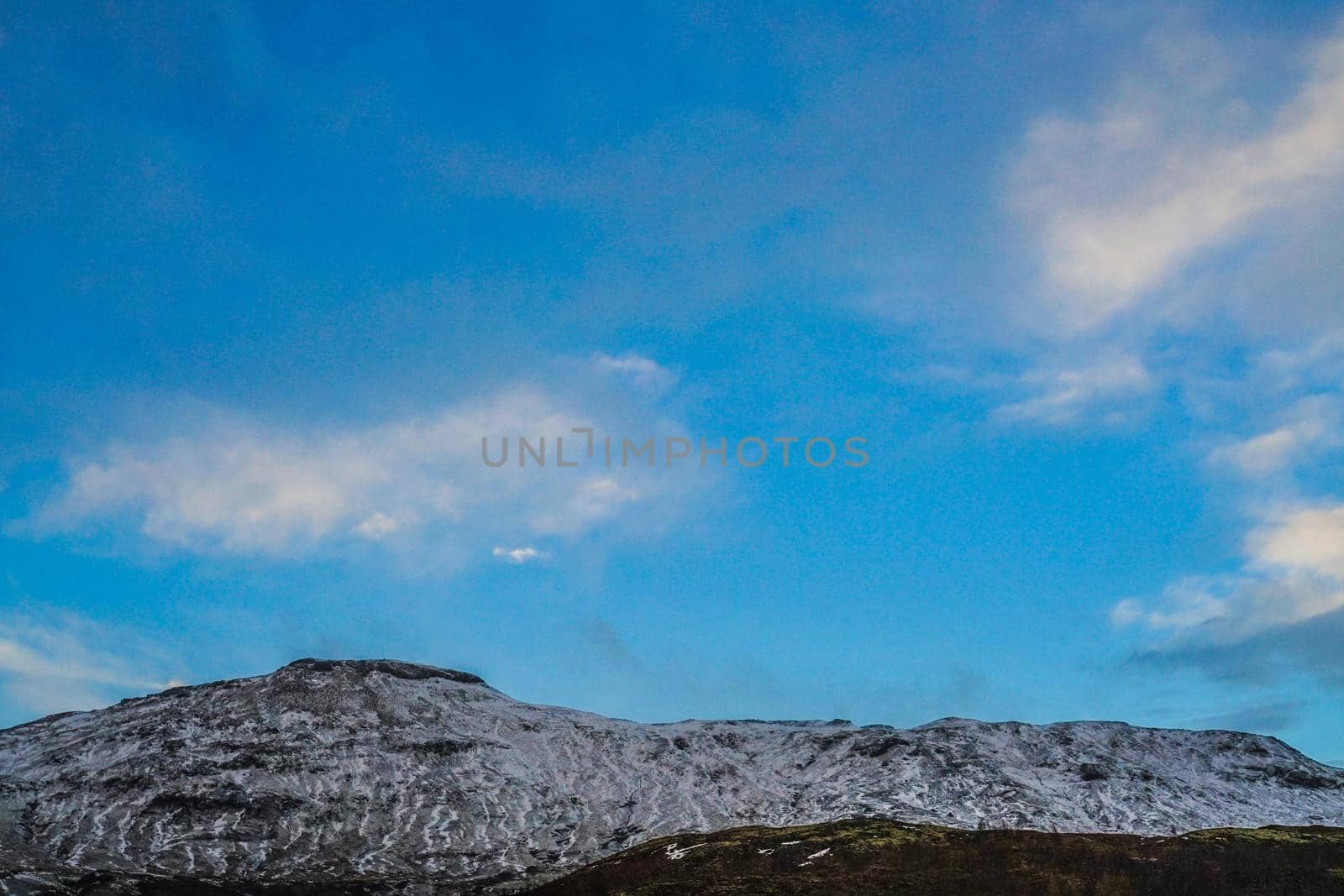 Icelands snowy mountain and blue sky. Shooting Location: Iceland, Lay Cavik