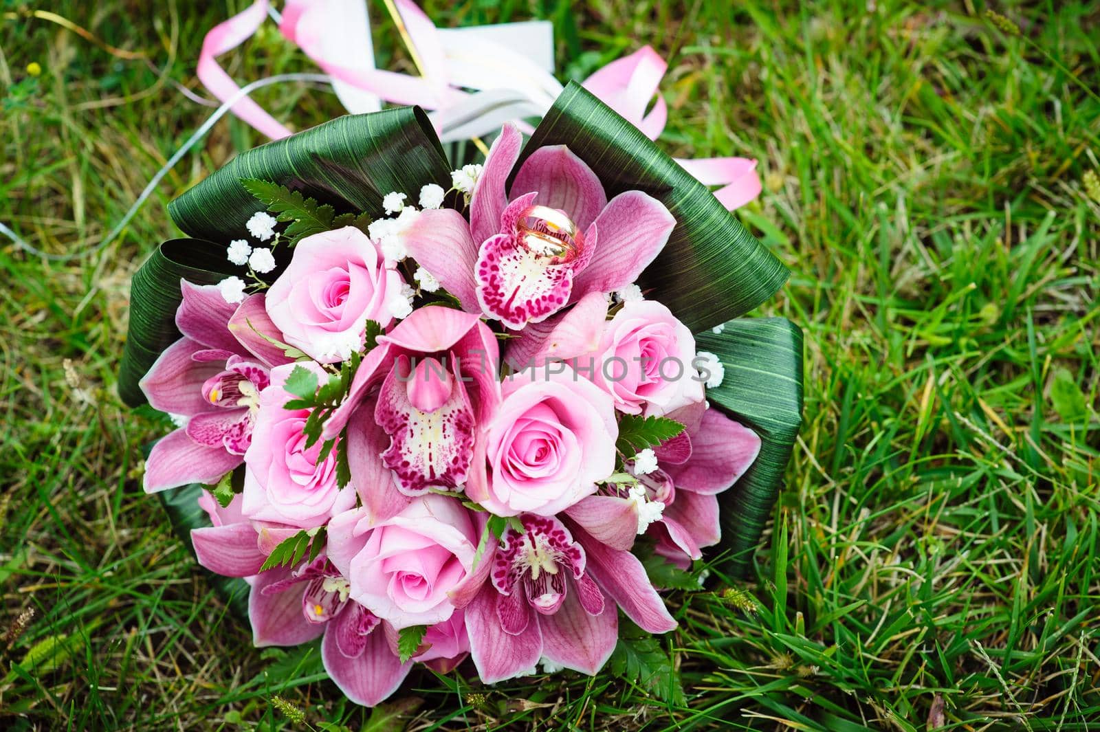 Bridal wedding bouquet of flowers. Wedding bouquet of pink roses lying on a grass.